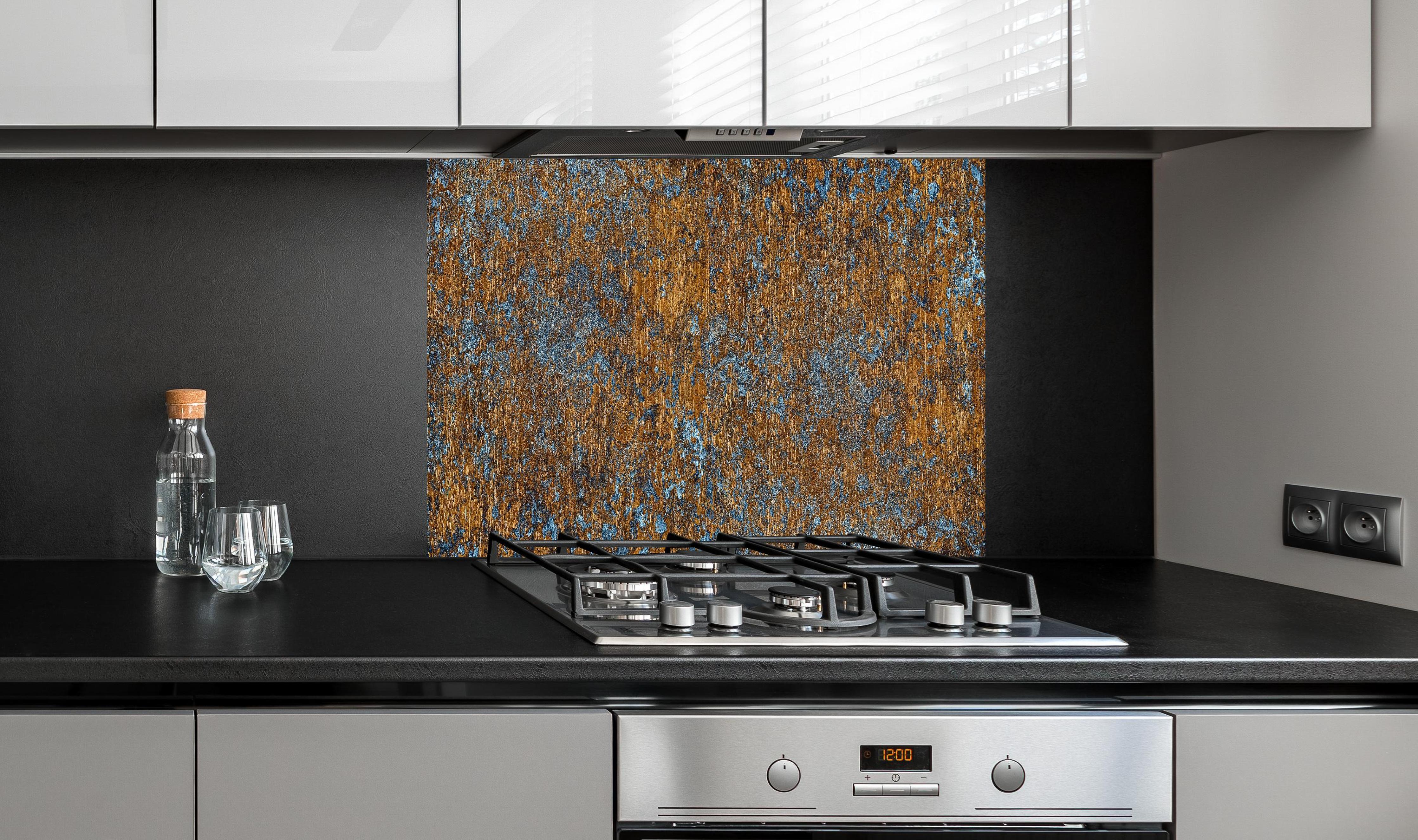 Spritzschutz - Gold-blaue alte Metalltextur hinter einem Cerankochfeld zwischen Holz-Kochutensilien
