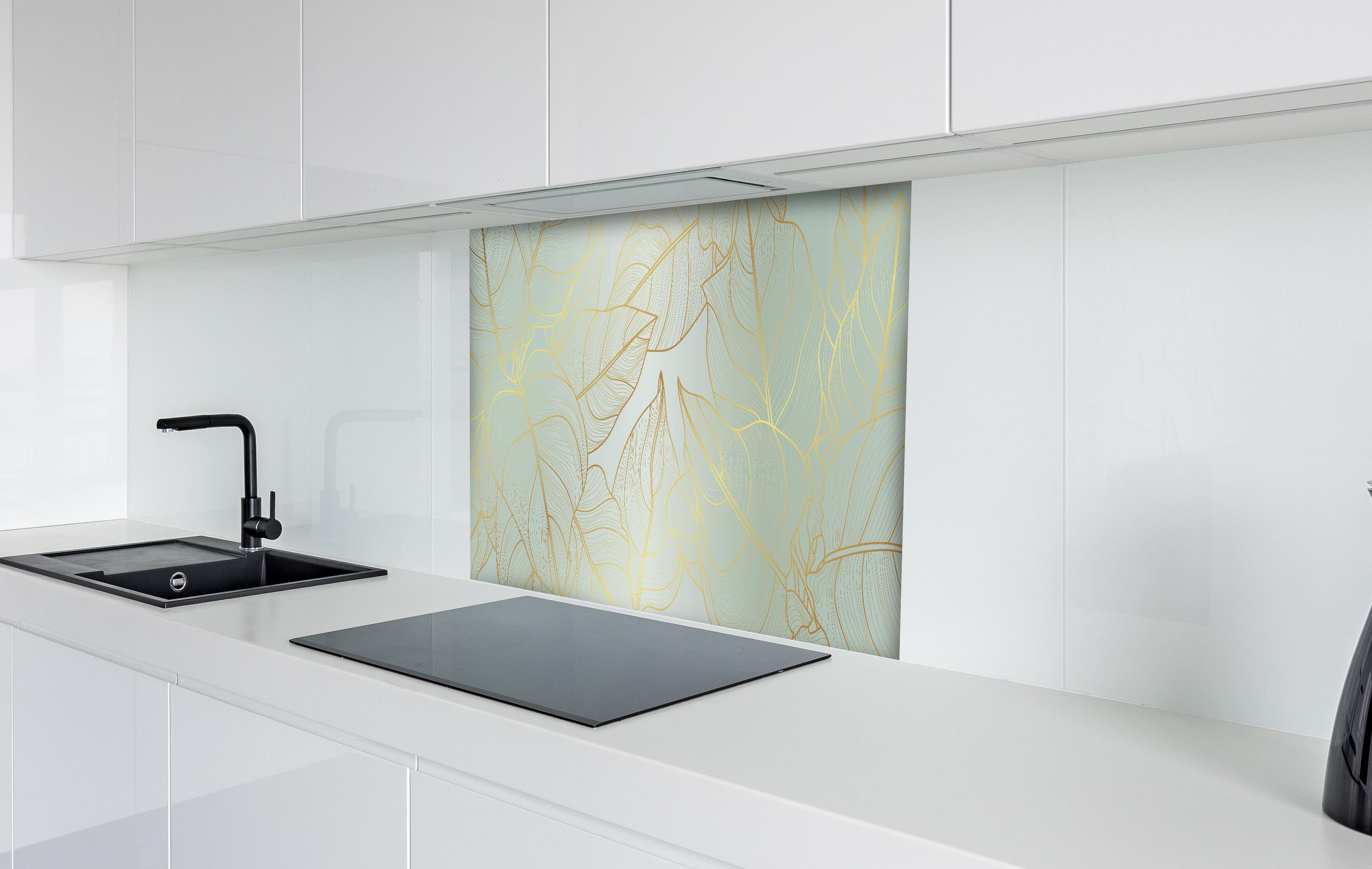 Spritzschutz - Goldener Blatt-Design Hintergrund hinter einem Cerankochfeld zwischen Holz-Kochutensilien
