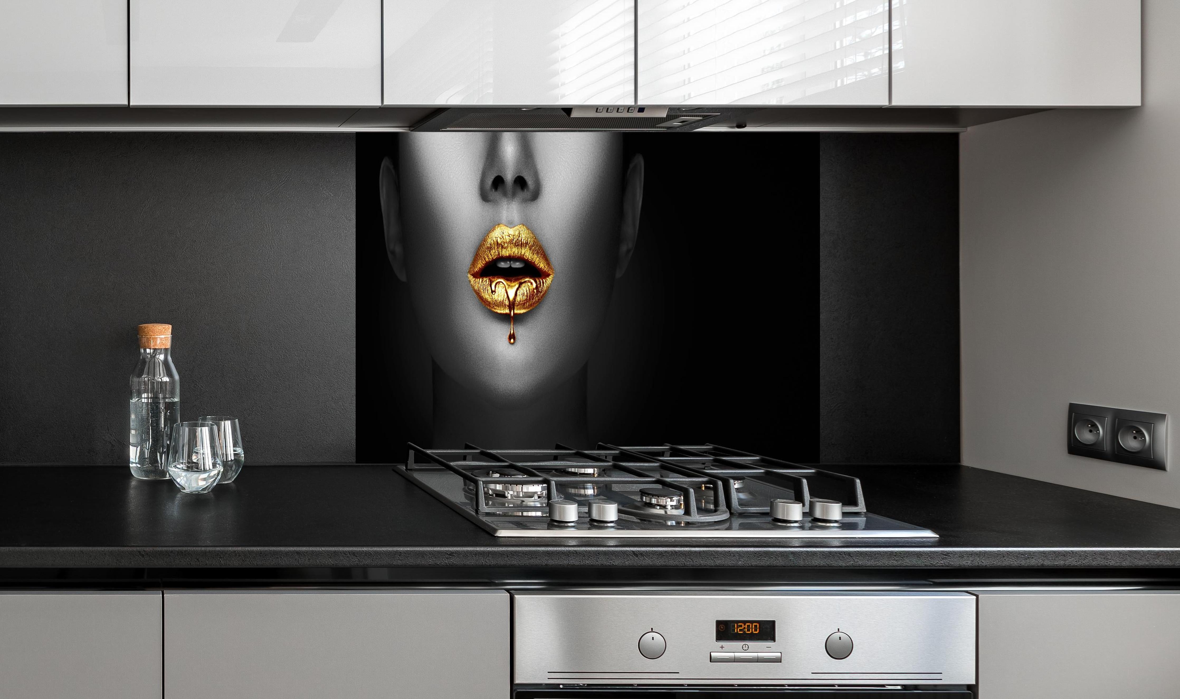 Spritzschutz - Goldener Lipgloss auf sexy Lippen Kunst hinter einem Cerankochfeld zwischen Holz-Kochutensilien
