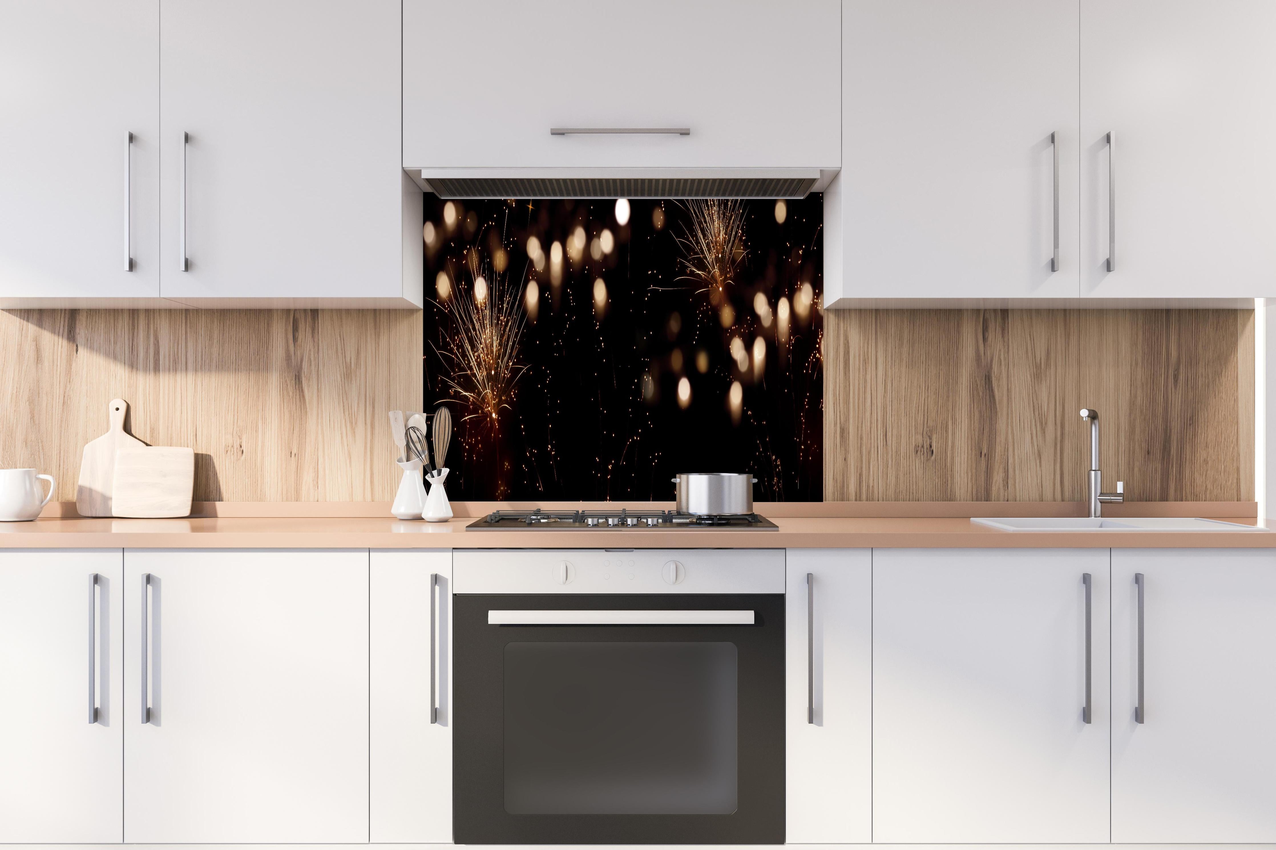 Spritzschutz - Goldenes Feuerwerk am Nachthimmel hinter einem Cerankochfeld zwischen Holz-Kochutensilien
