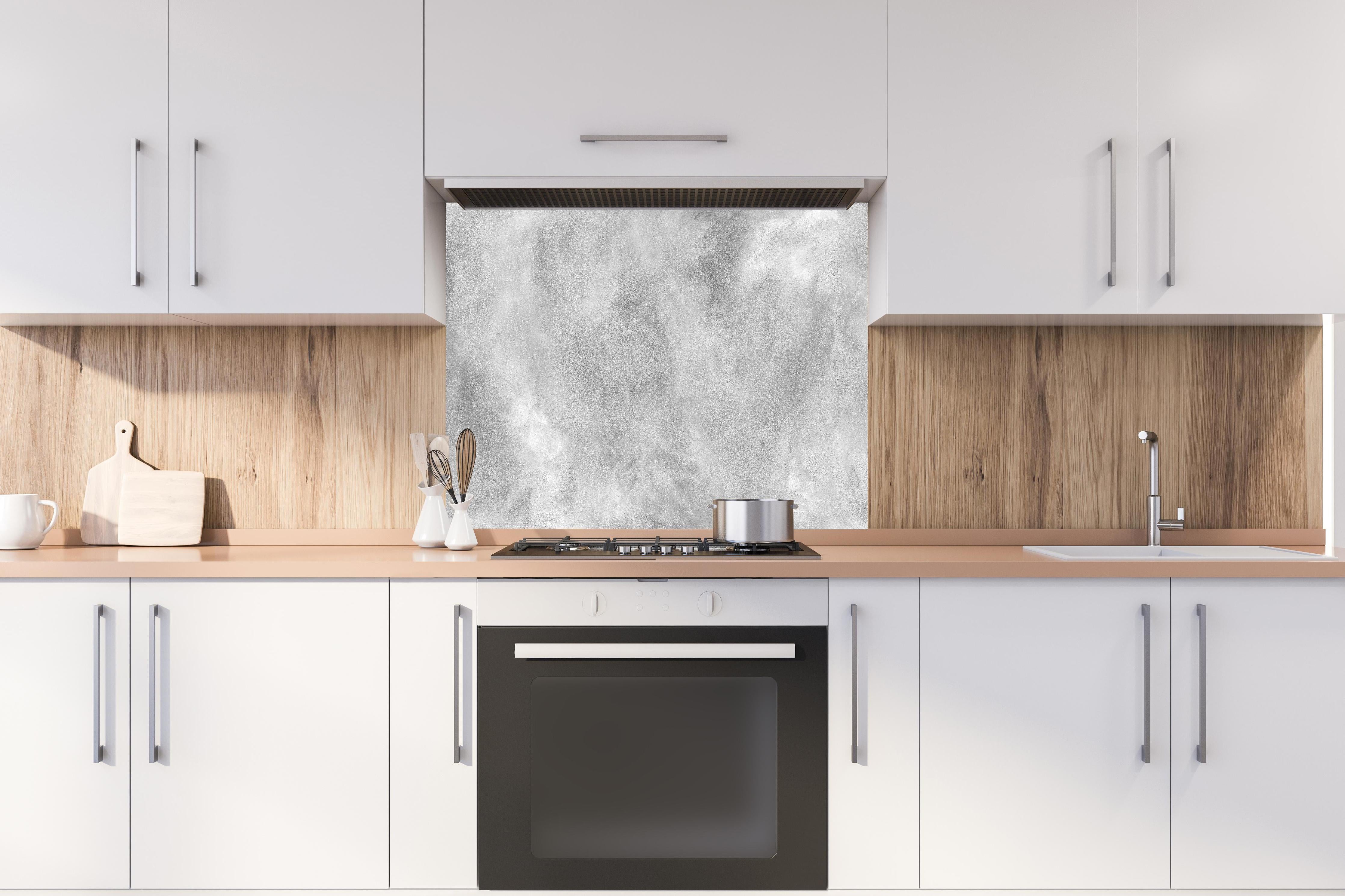 Spritzschutz - Gräuliches Marmor Design hinter einem Cerankochfeld zwischen Holz-Kochutensilien
