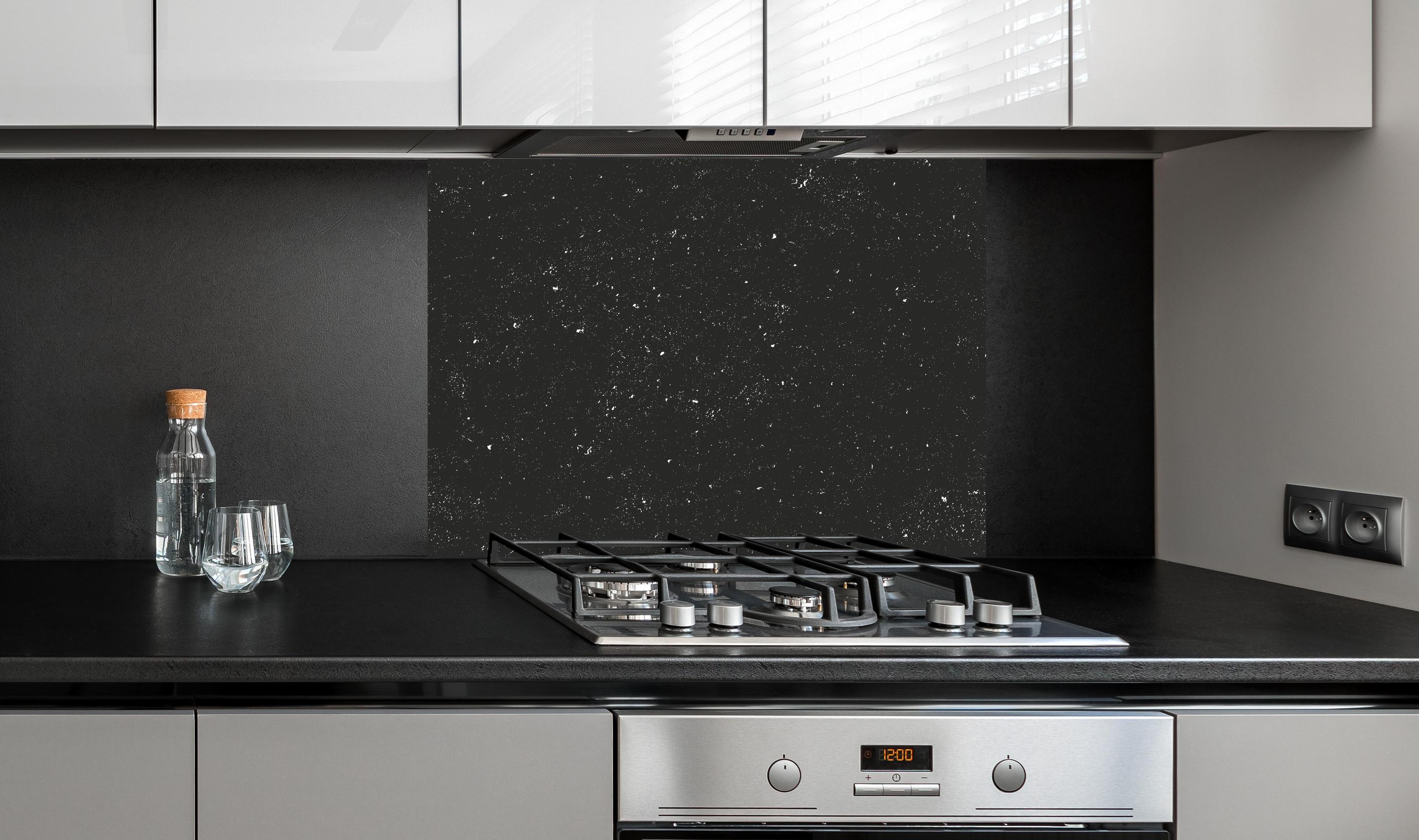 Spritzschutz - Grau-Schwarze Textur mit Betonrisseffekt hinter einem Cerankochfeld zwischen Holz-Kochutensilien
