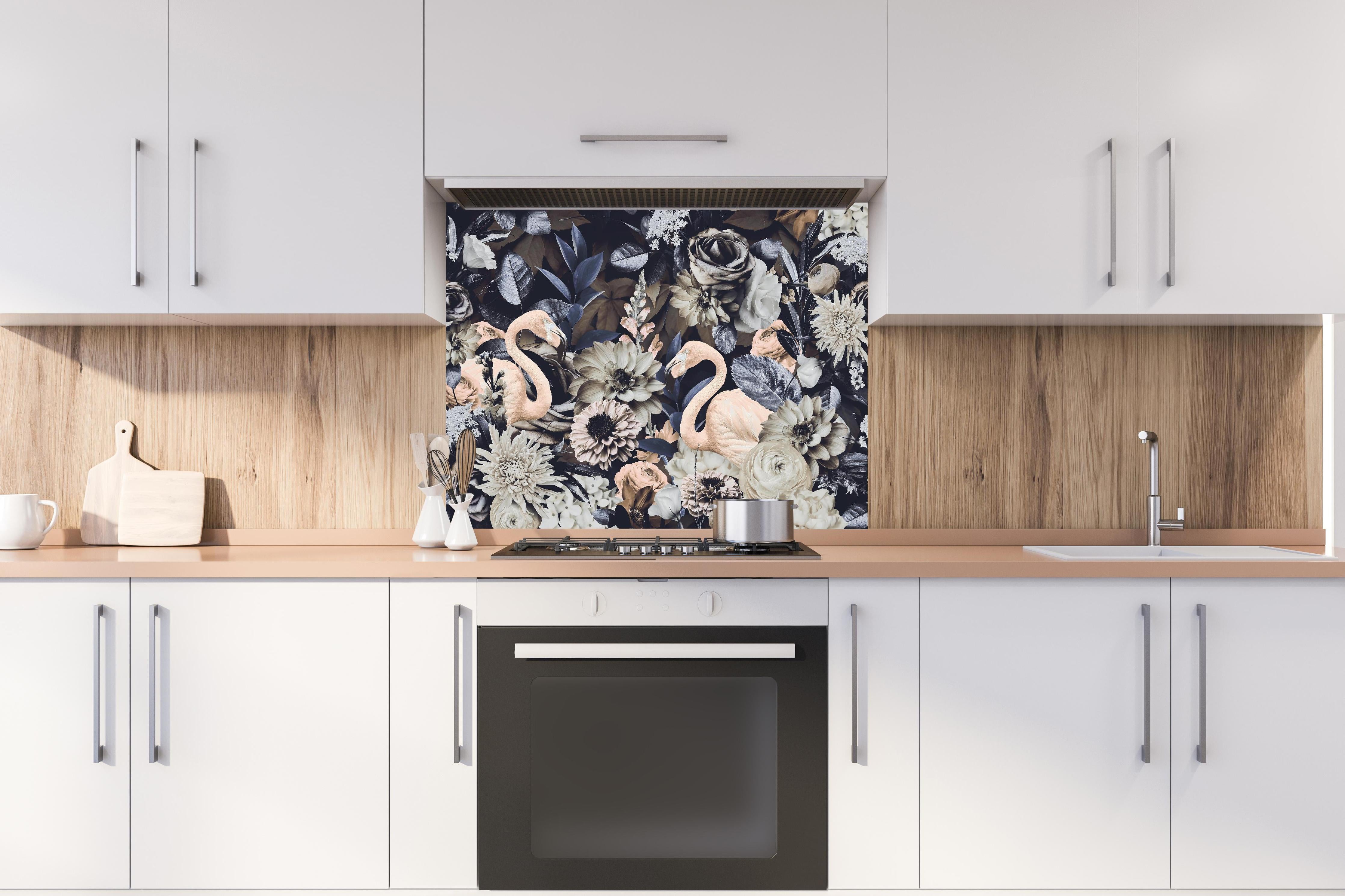 Spritzschutz - Grau-Weiße Flamingos im Blumenmeer hinter einem Cerankochfeld zwischen Holz-Kochutensilien
