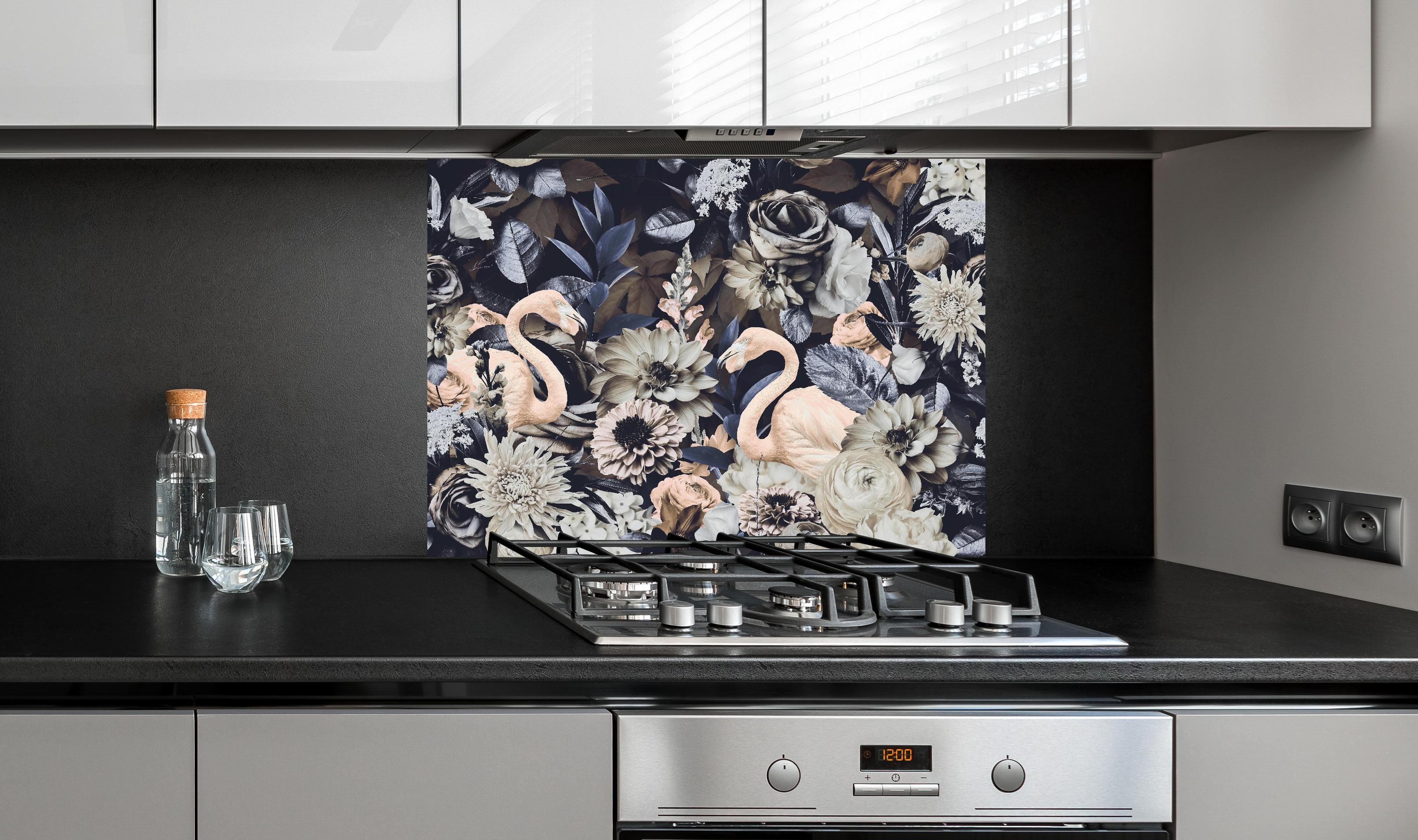 Spritzschutz - Grau-Weiße Flamingos im Blumenmeer hinter einem Cerankochfeld zwischen Holz-Kochutensilien
