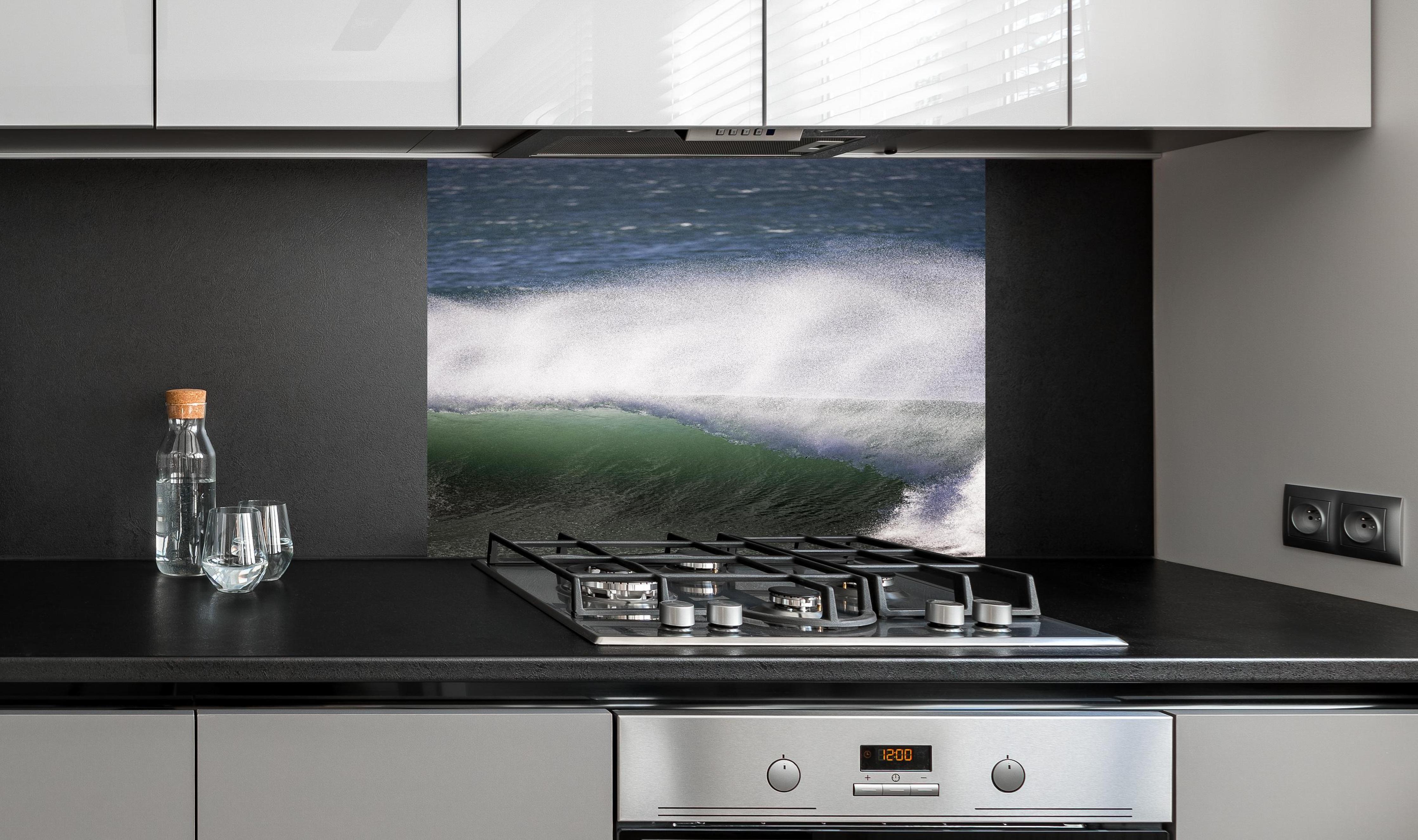 Spritzschutz - Grau-Weißes Meeresschauspiel mit Kraft hinter einem Cerankochfeld zwischen Holz-Kochutensilien
