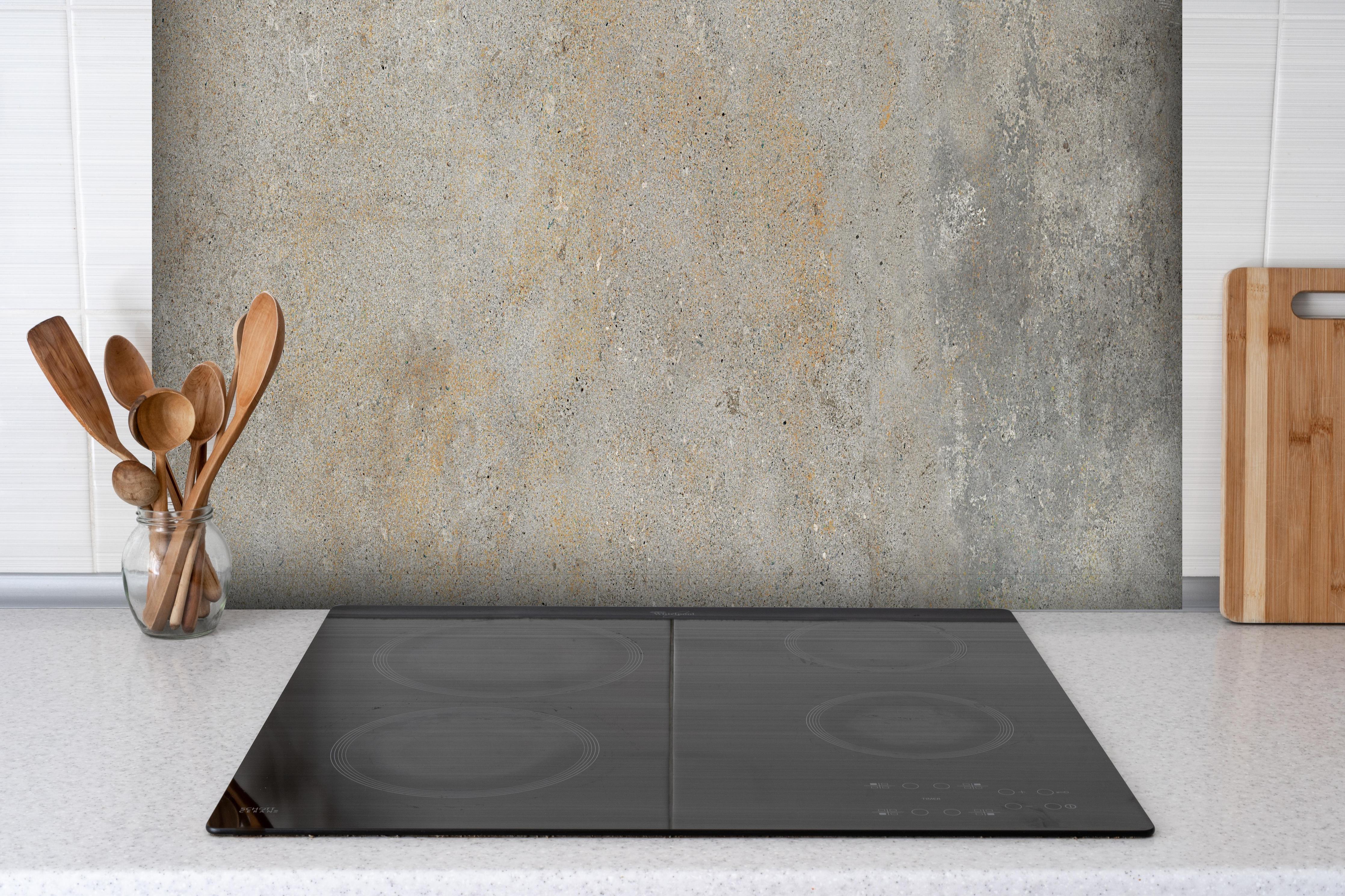 Spritzschutz - Grau städtische Marmortextur hinter einem Cerankochfeld zwischen Holz-Kochutensilien
