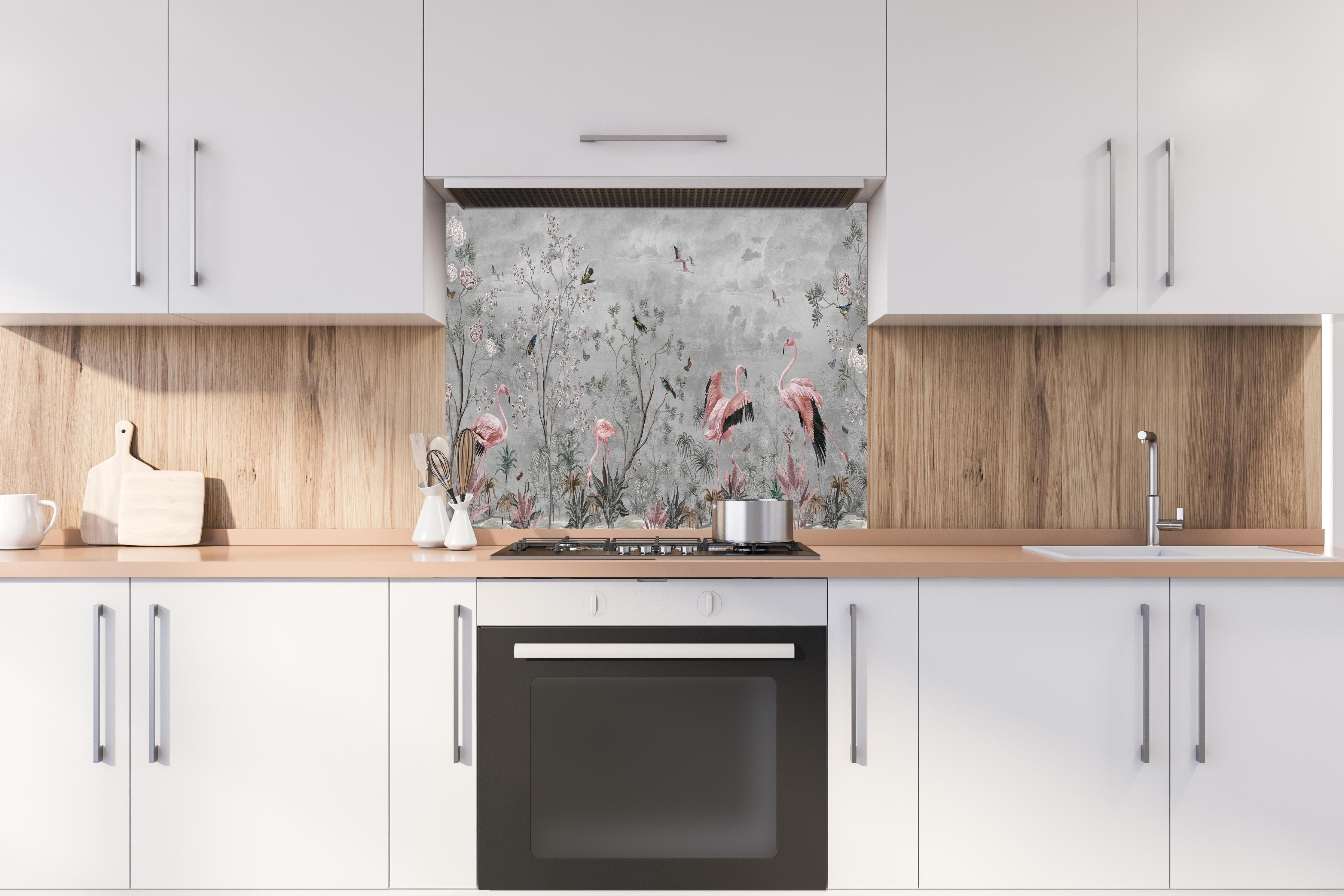 Spritzschutz - Graue Dschungeltapete mit Flamingos hinter einem Cerankochfeld zwischen Holz-Kochutensilien
