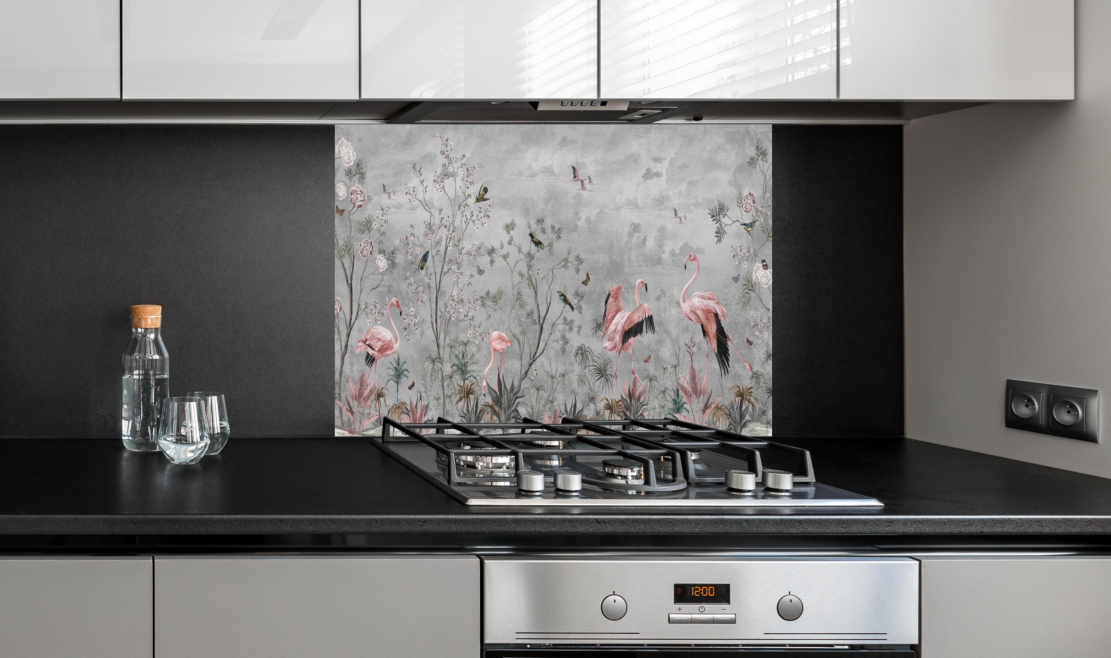 Spritzschutz - Graue Dschungeltapete mit Flamingos hinter einem Cerankochfeld zwischen Holz-Kochutensilien
