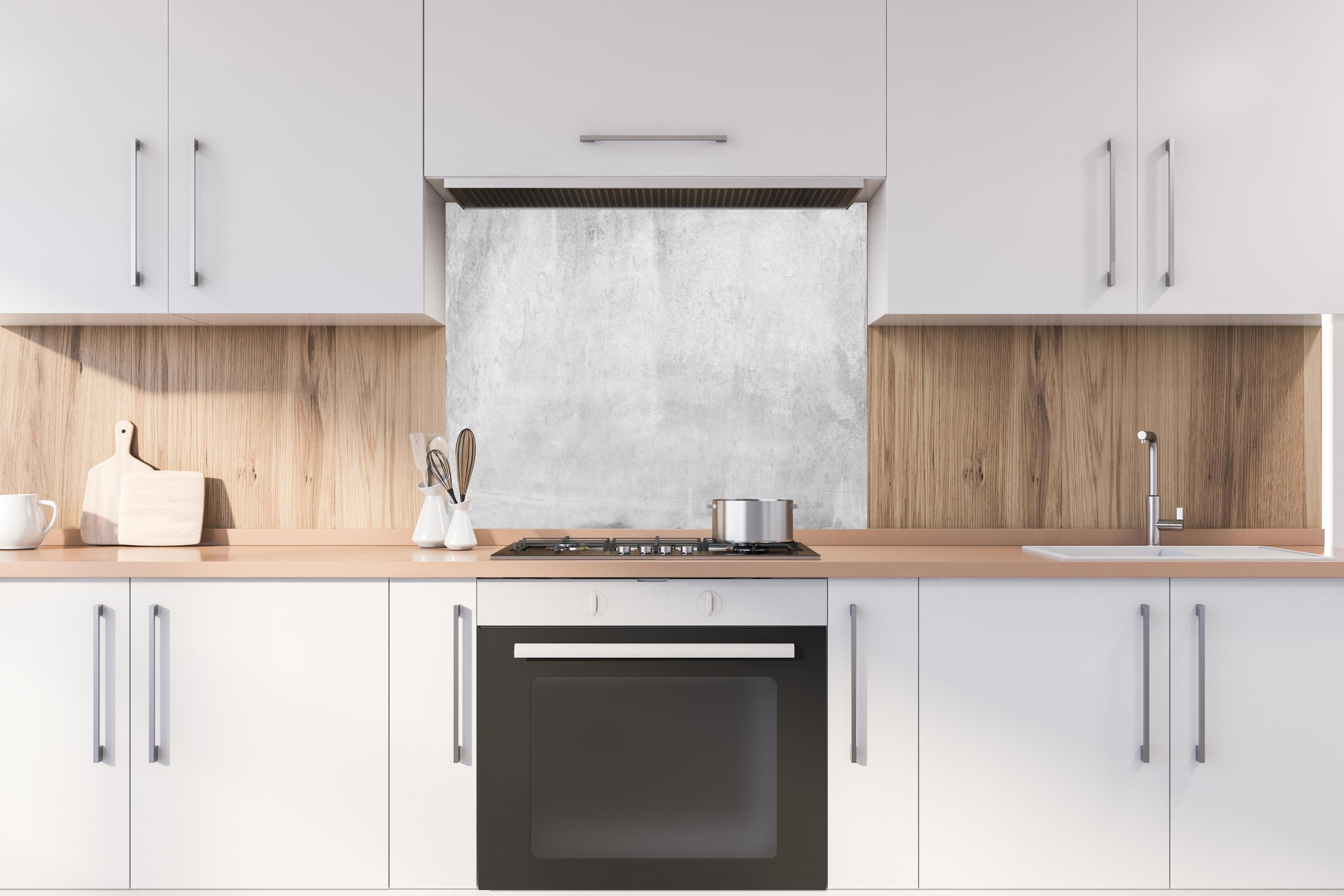 Spritzschutz - Graue Grunge Betonwand hinter einem Cerankochfeld zwischen Holz-Kochutensilien
