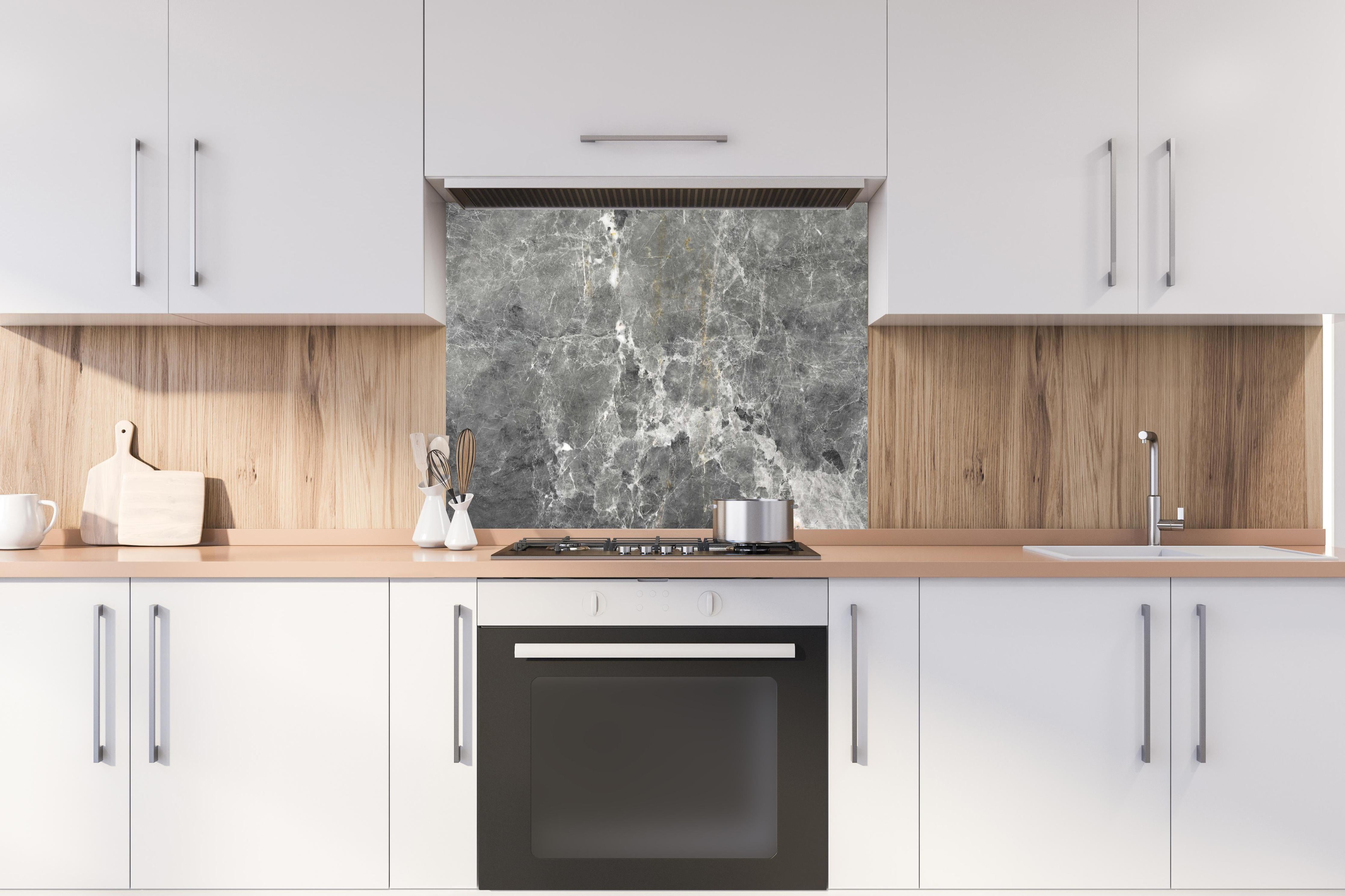 Spritzschutz - Graue Marmorstein Textur hinter einem Cerankochfeld zwischen Holz-Kochutensilien
