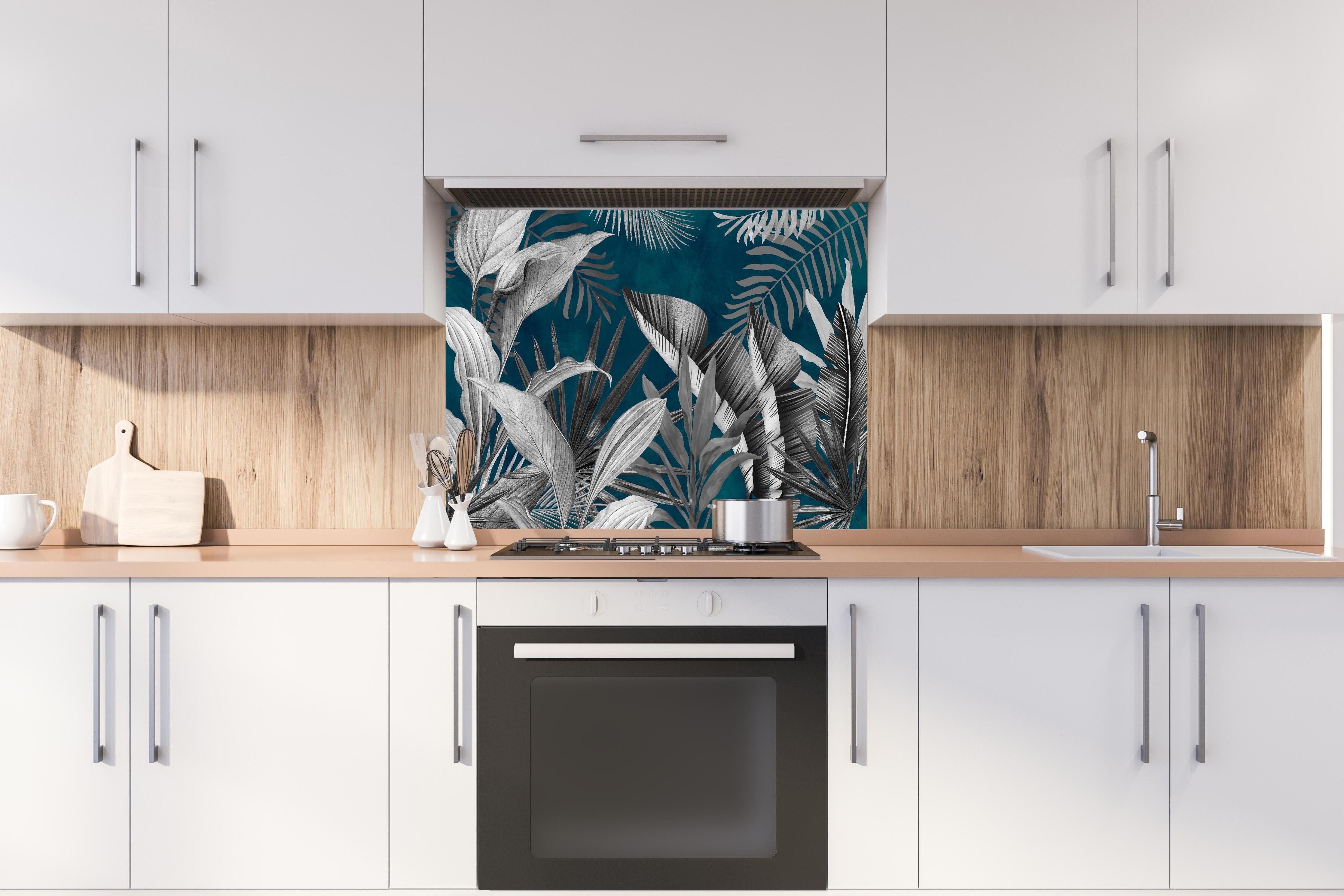 Spritzschutz - Graue Pflanzen auf blauem Hintergrund hinter einem Cerankochfeld zwischen Holz-Kochutensilien
