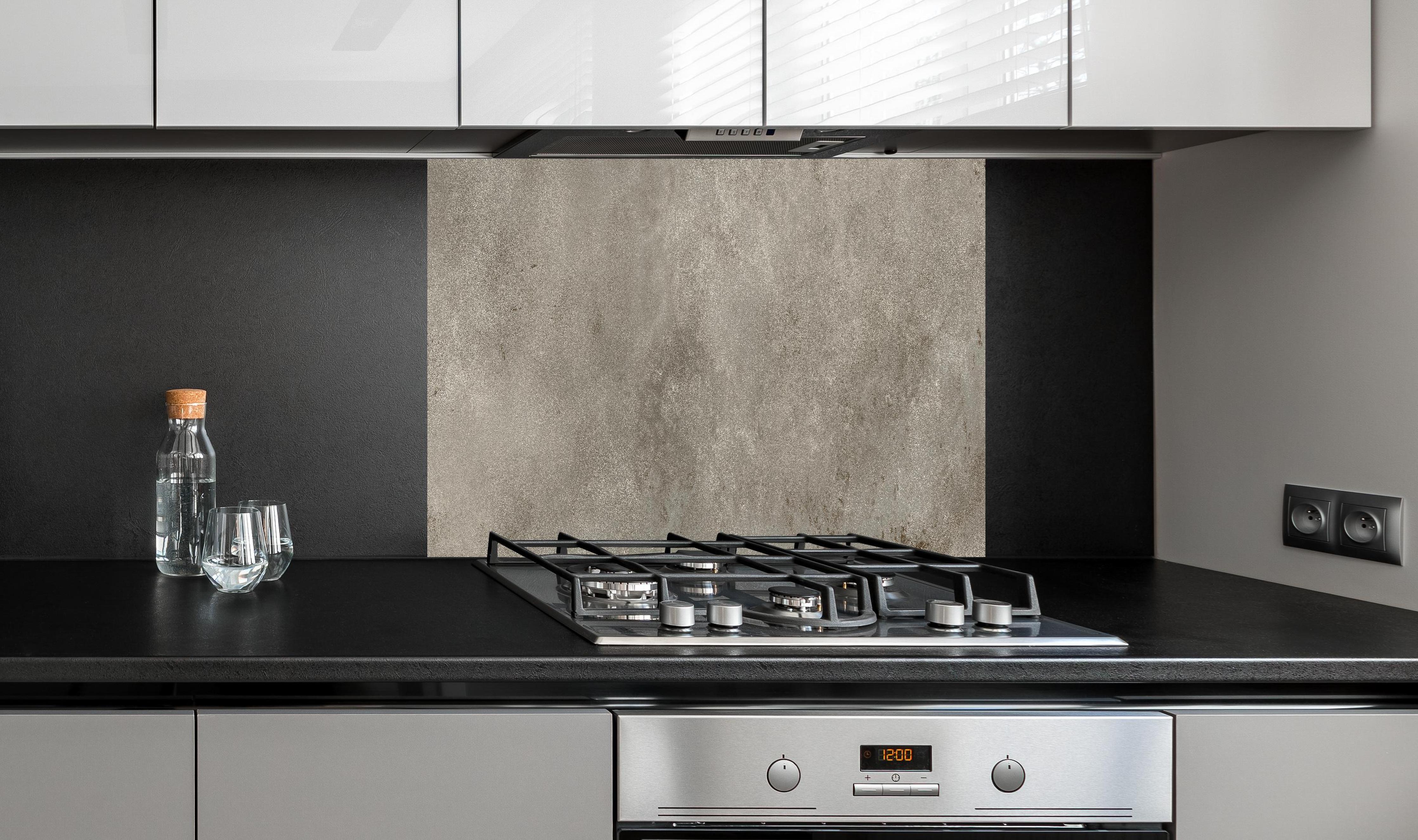 Spritzschutz - Graue alte Kalksteinwand hinter einem Cerankochfeld zwischen Holz-Kochutensilien
