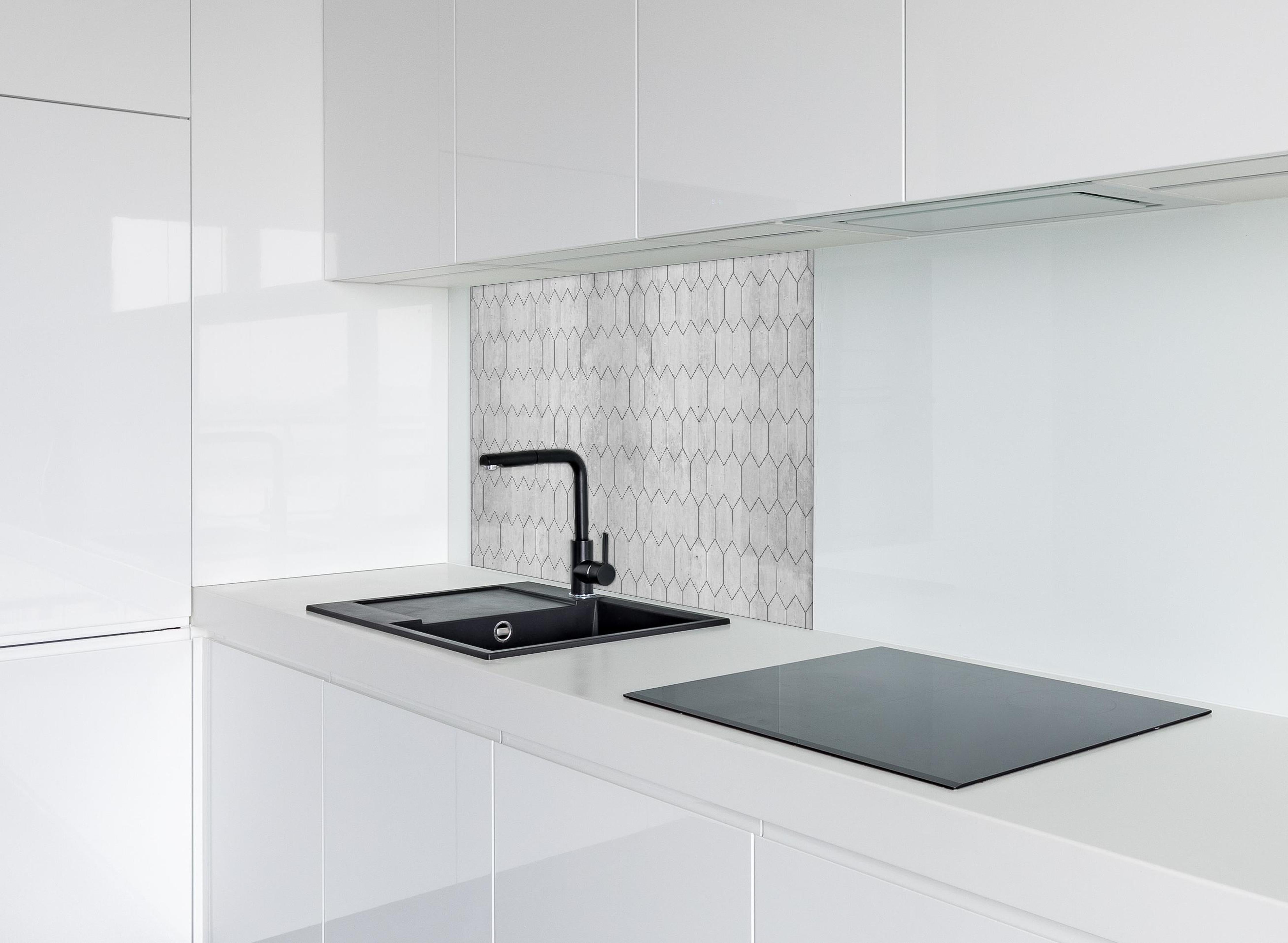 Spritzschutz - Graue sechseckige Mustern hinter einem Cerankochfeld zwischen Holz-Kochutensilien
