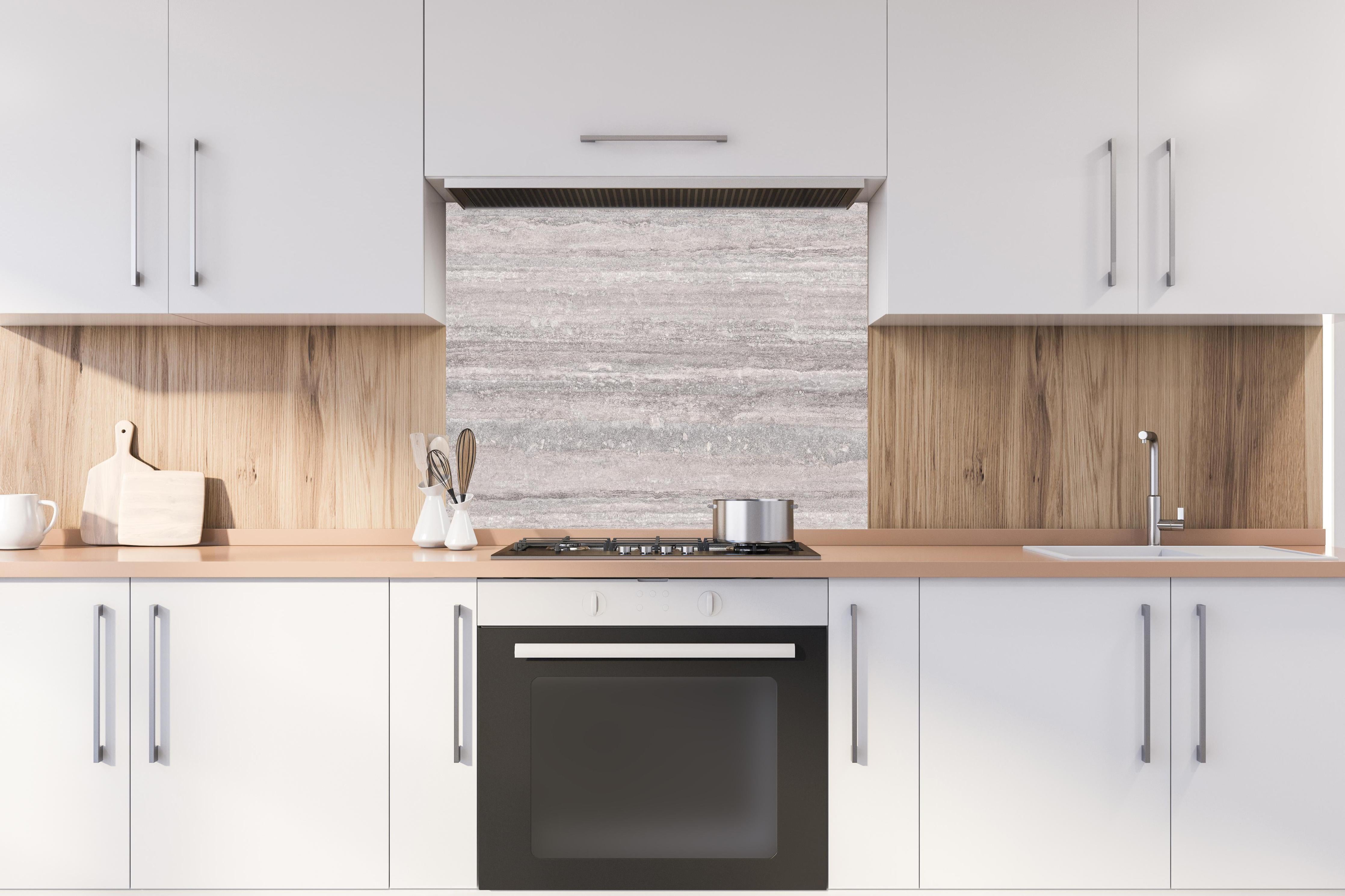 Spritzschutz - Grauer Travertin Stein hinter einem Cerankochfeld zwischen Holz-Kochutensilien
