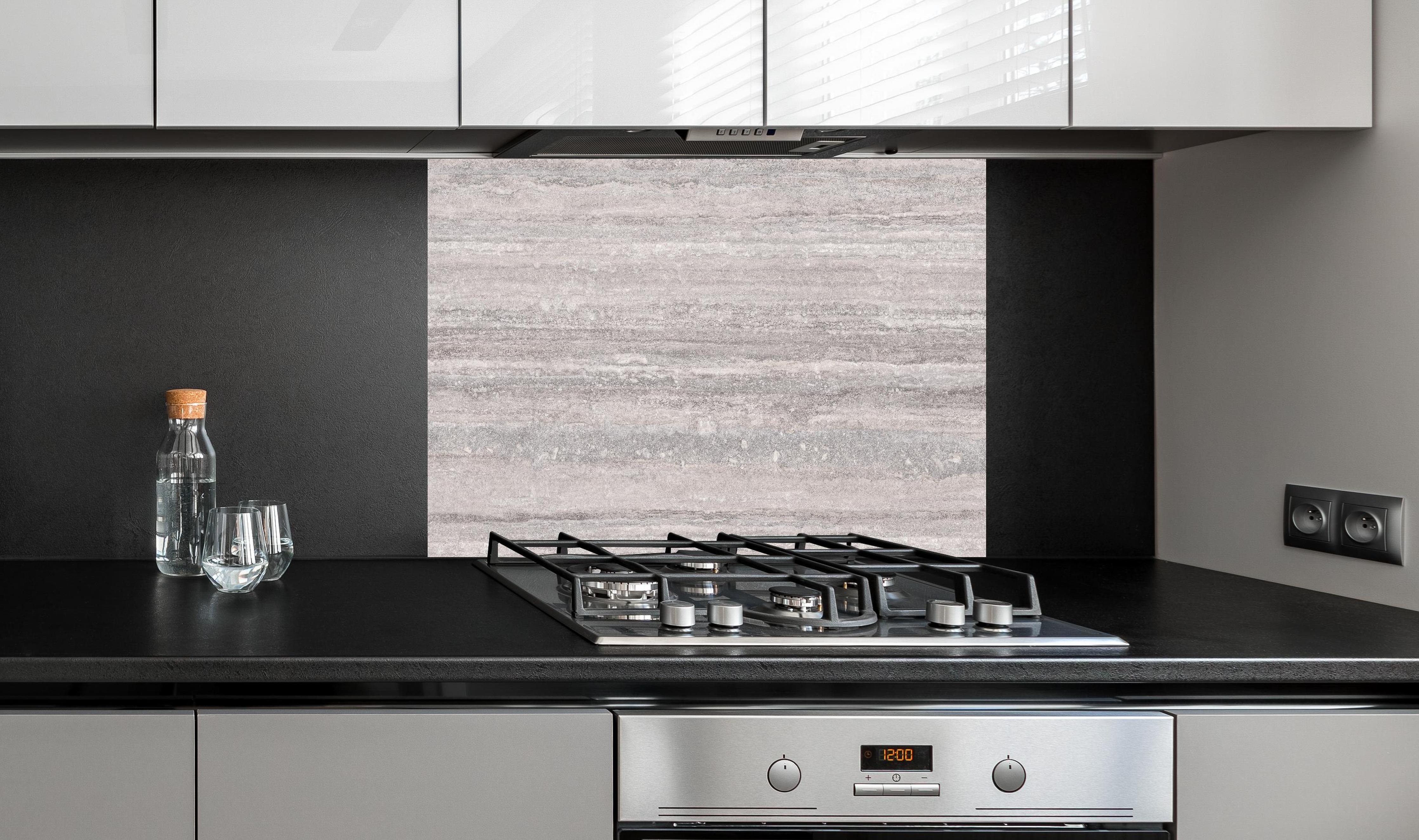 Spritzschutz - Grauer Travertin Stein hinter einem Cerankochfeld zwischen Holz-Kochutensilien
