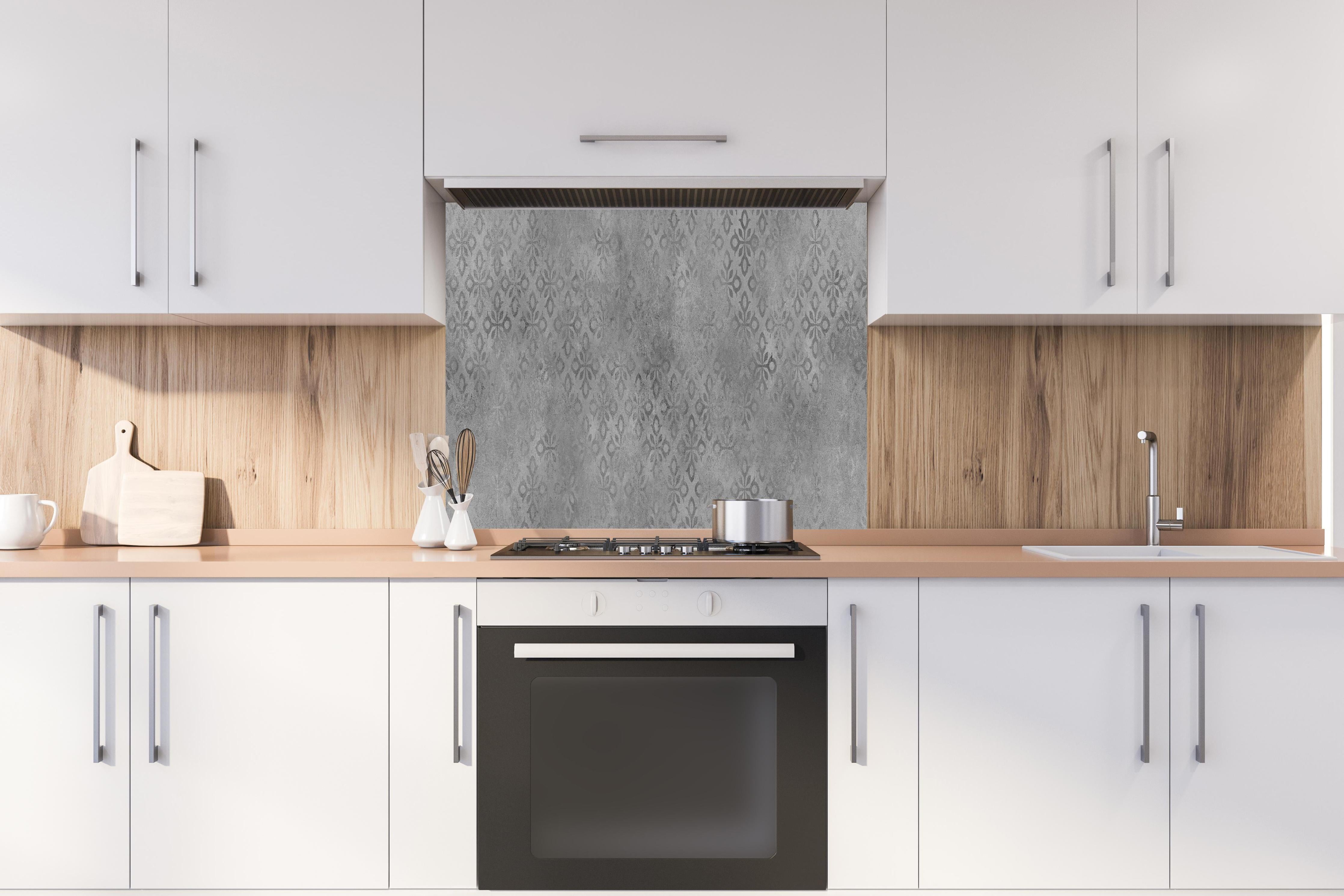 Spritzschutz - Graues Ornament Muster  hinter einem Cerankochfeld zwischen Holz-Kochutensilien
