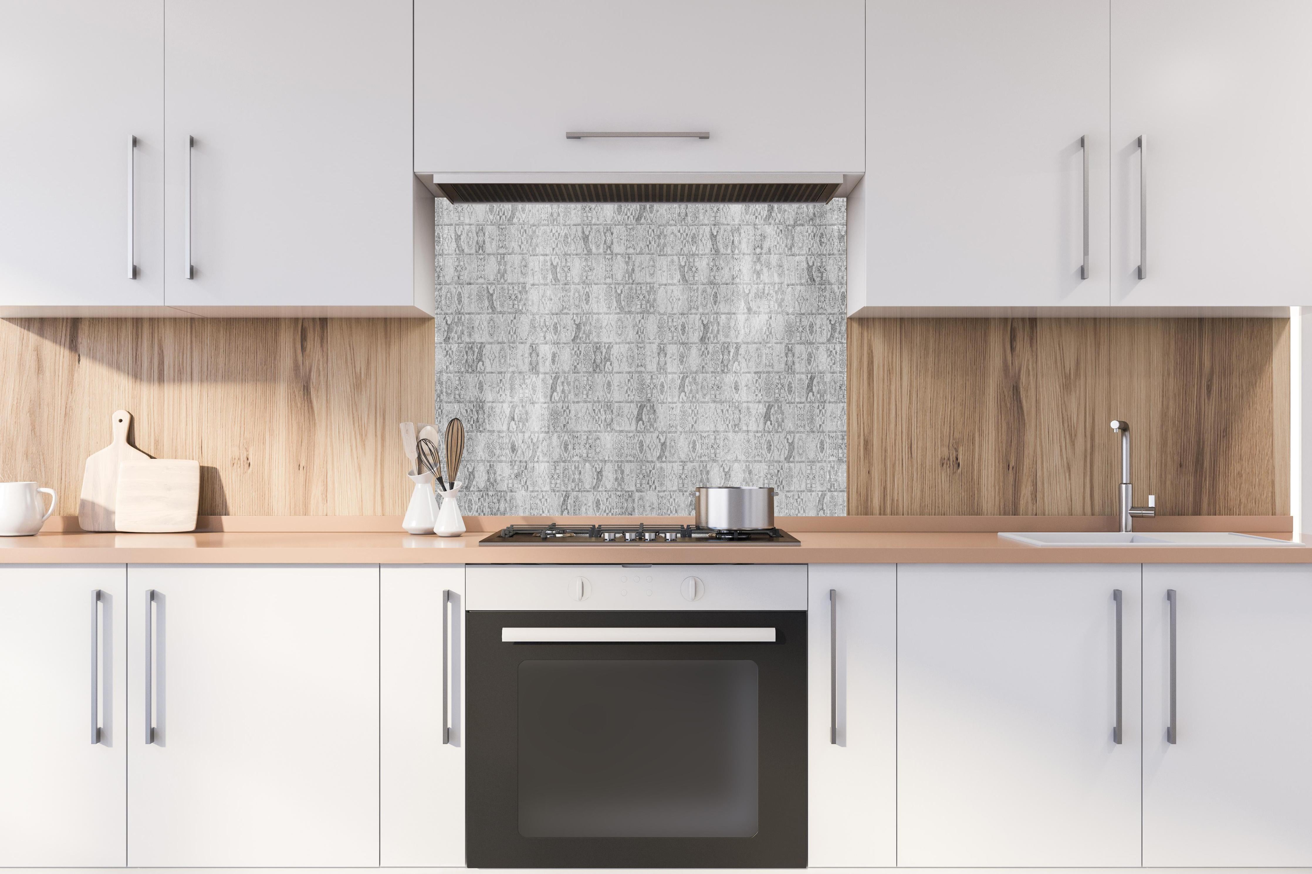 Spritzschutz - Graues weißes Mosaikmotiv hinter einem Cerankochfeld zwischen Holz-Kochutensilien
