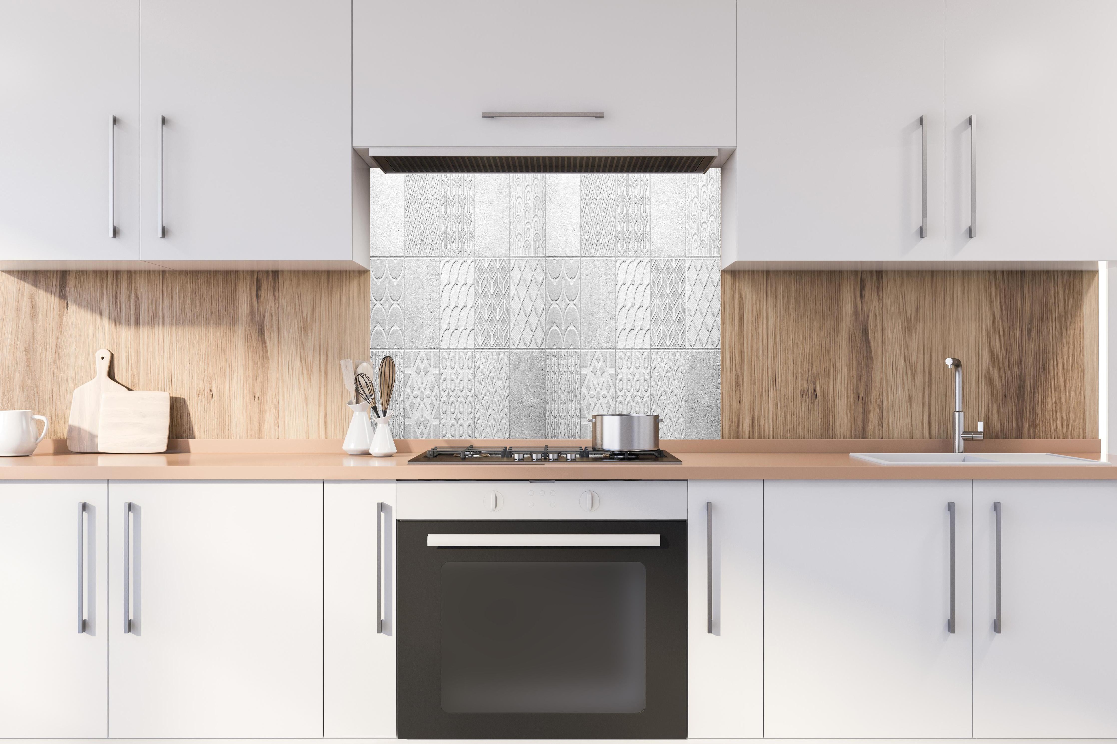 Spritzschutz - Graues weißes Vintage Mosaikmotiv hinter einem Cerankochfeld zwischen Holz-Kochutensilien
