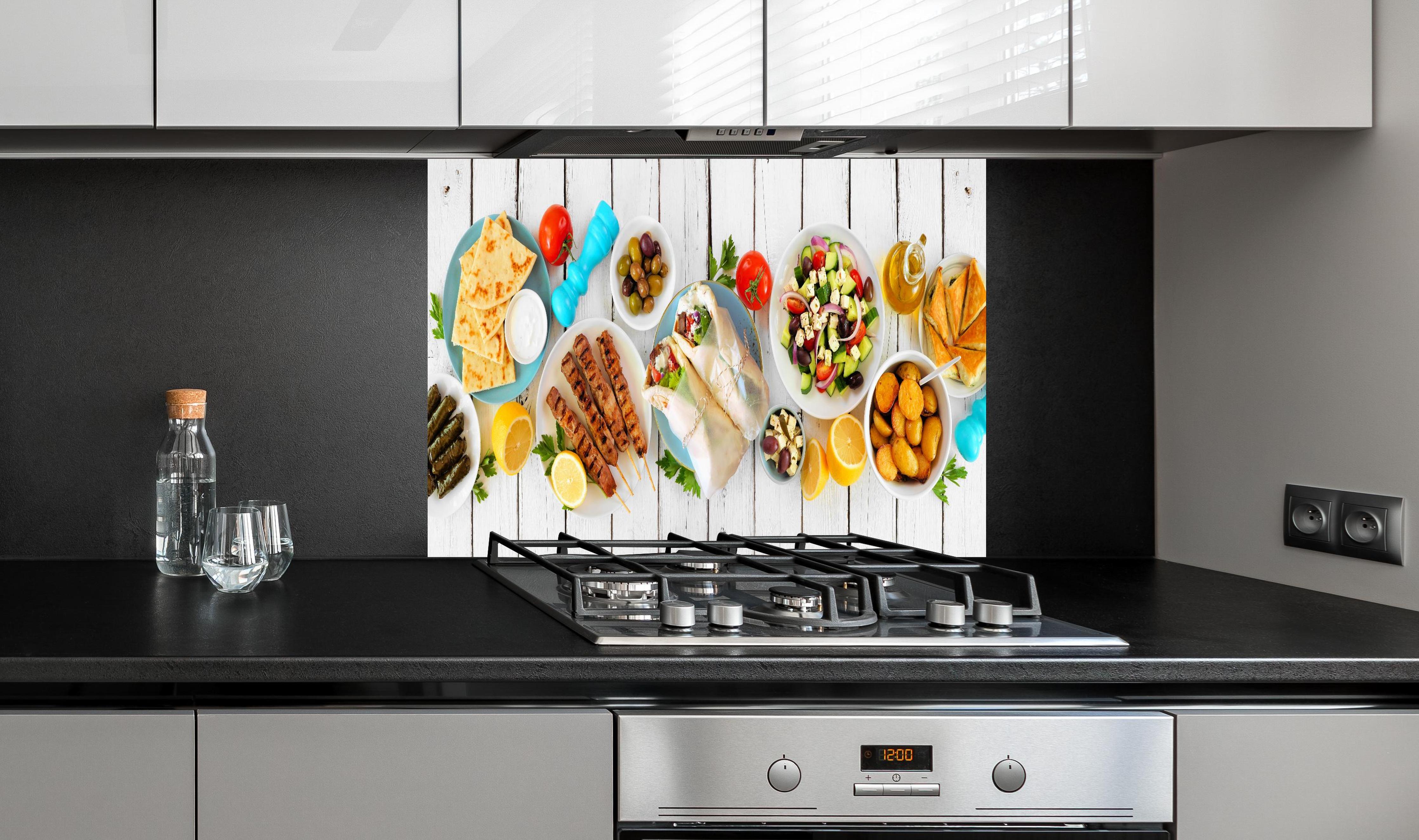 Spritzschutz - Griechisches Essen hinter einem Cerankochfeld zwischen Holz-Kochutensilien
