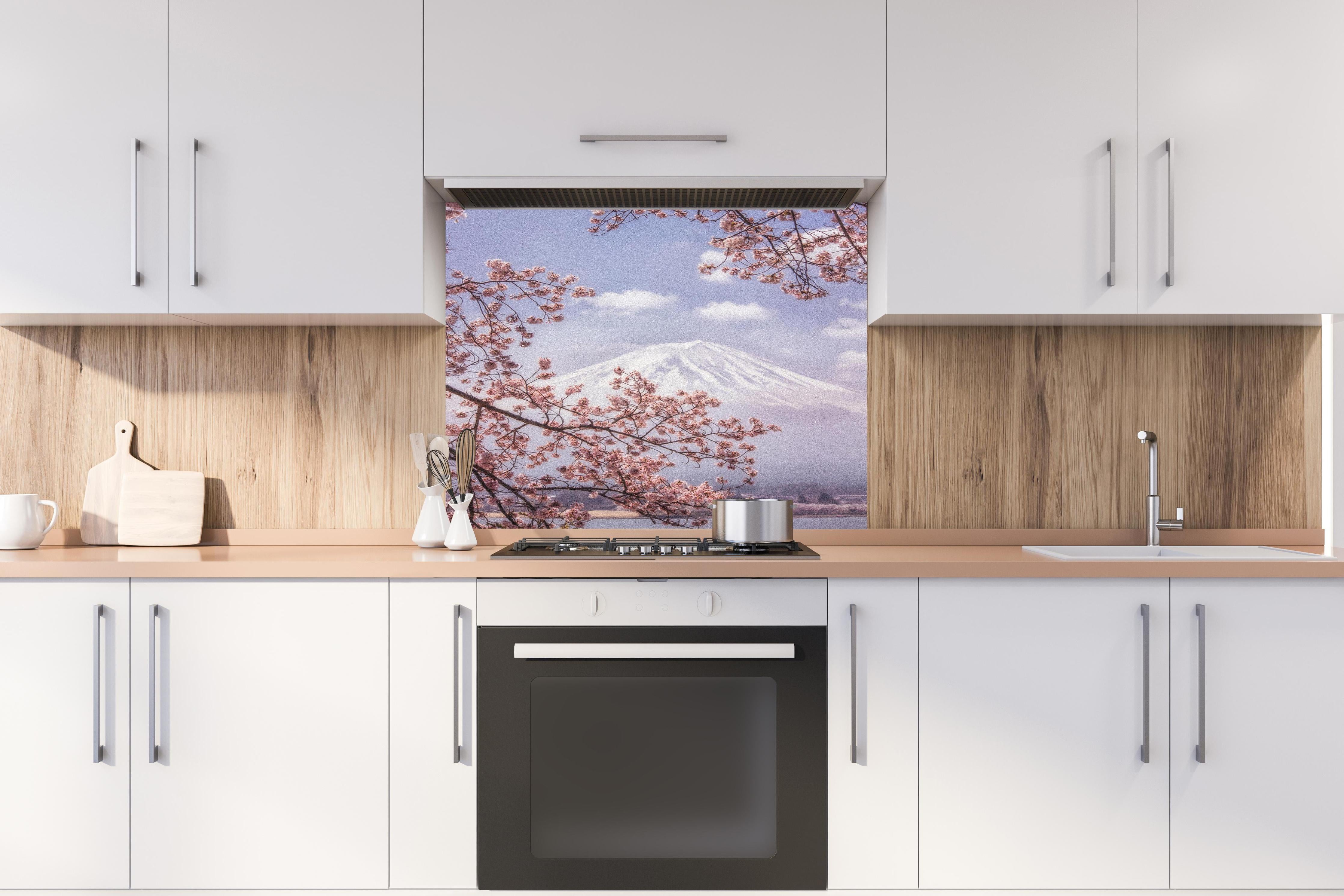 Spritzschutz - Großer Berg hinter Kirchblüten - Japan hinter einem Cerankochfeld zwischen Holz-Kochutensilien
