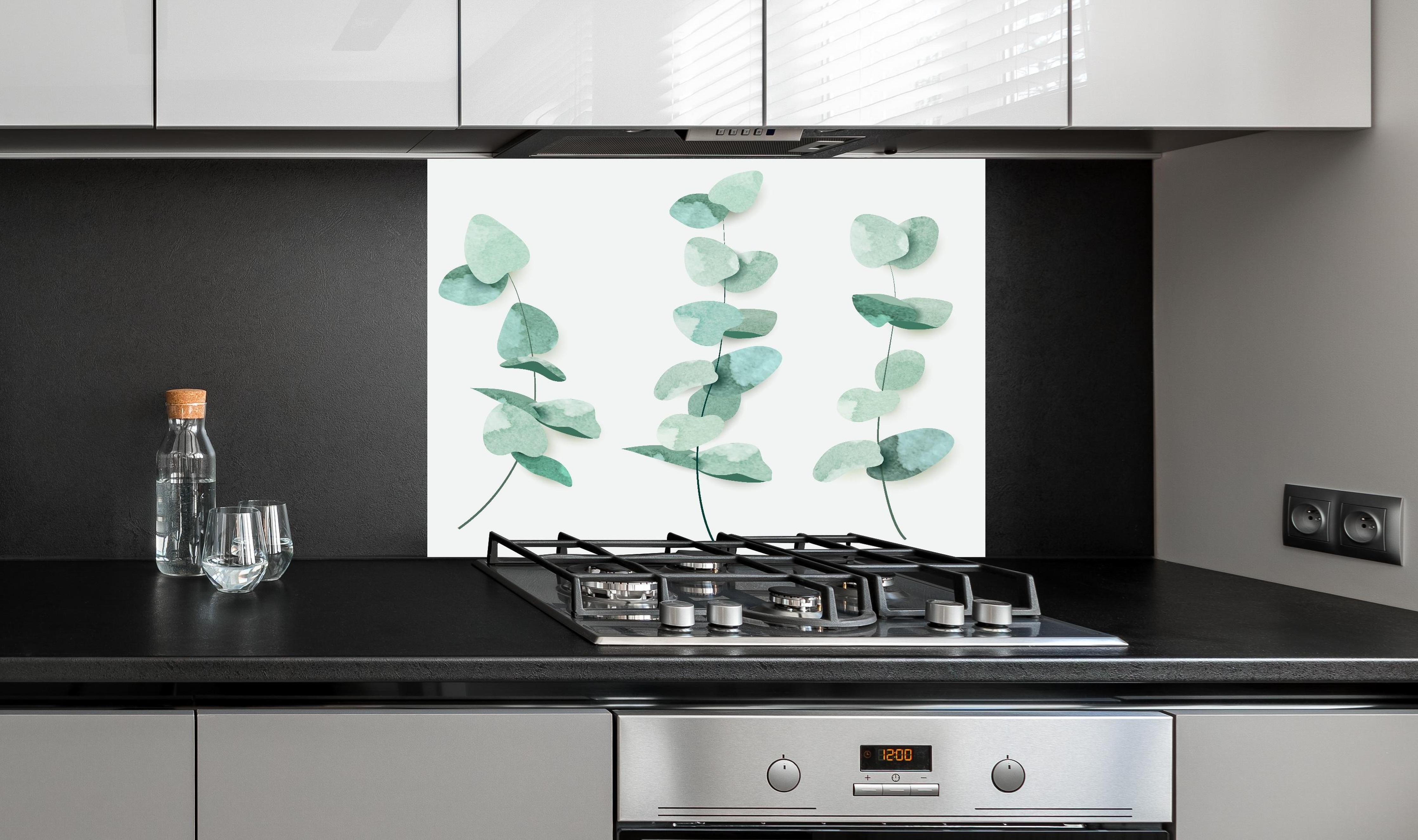 Spritzschutz - Grüne Eukalyptusblätter Aquarell Kunst Dekor hinter einem Cerankochfeld zwischen Holz-Kochutensilien
