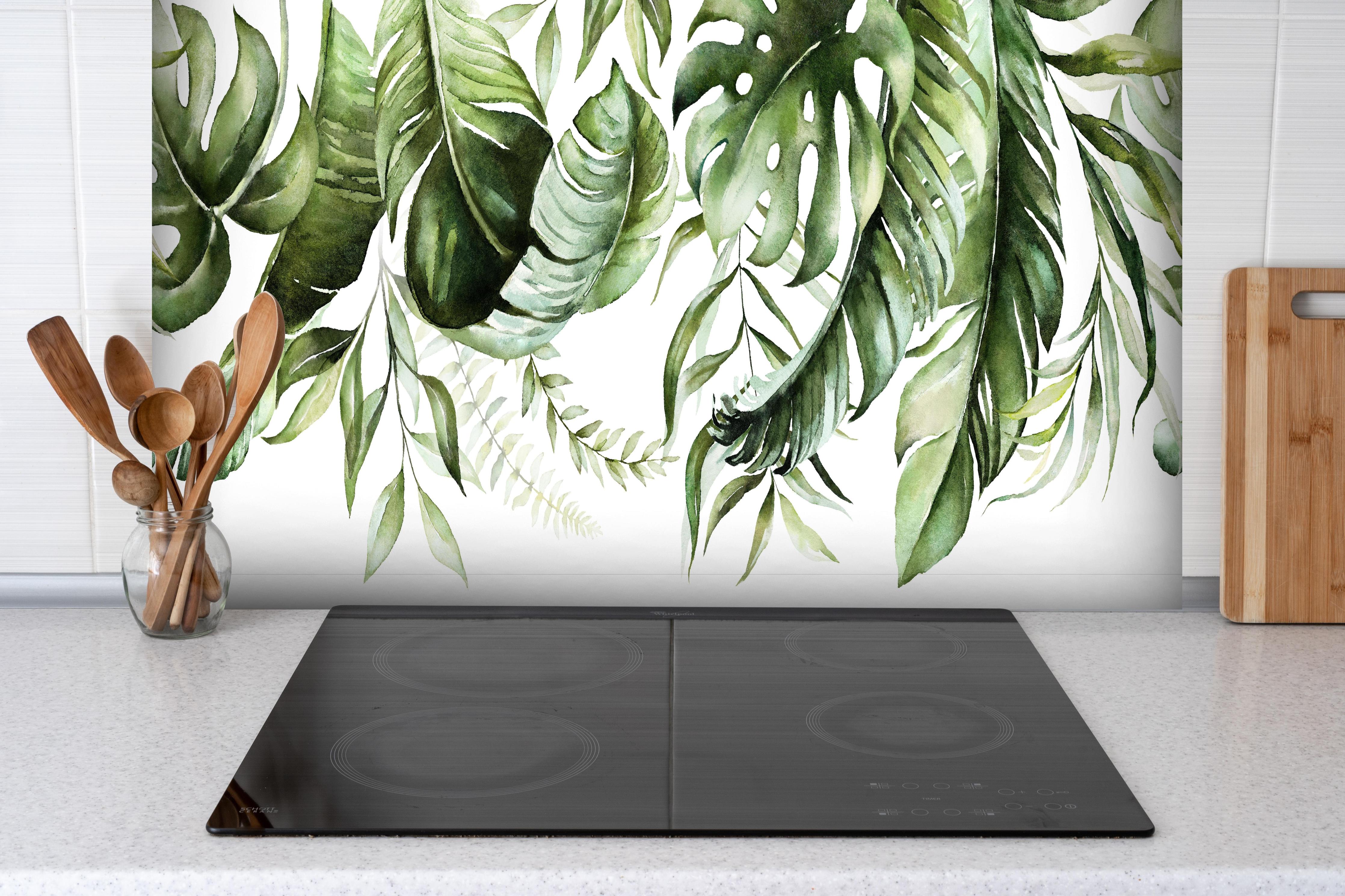 Spritzschutz - Handgemalte Grüne Tropenblätter Aquarellkunst hinter einem Cerankochfeld zwischen Holz-Kochutensilien
