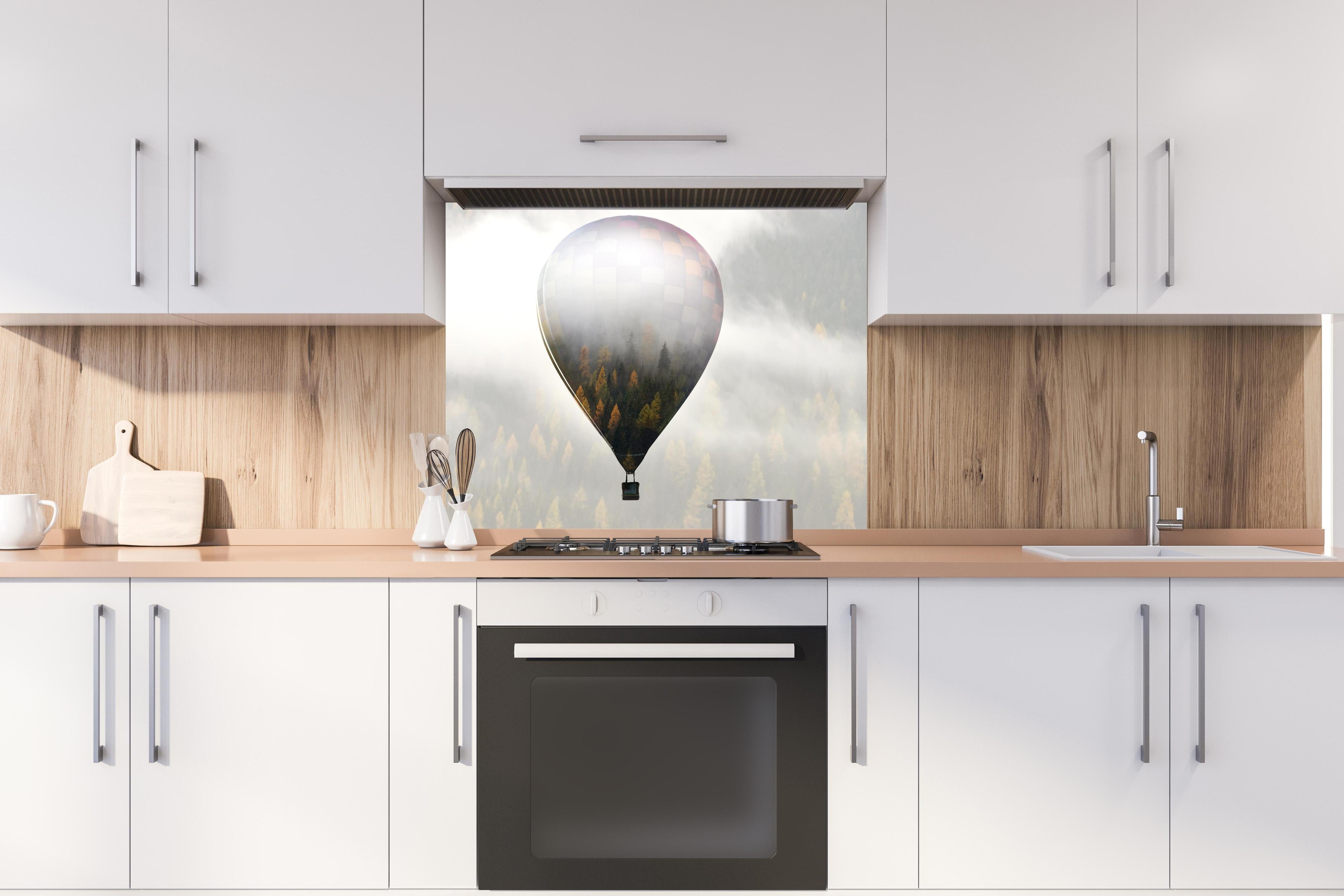 Spritzschutz - Heißluftballon - Spiegelung des Waldes hinter einem Cerankochfeld zwischen Holz-Kochutensilien
