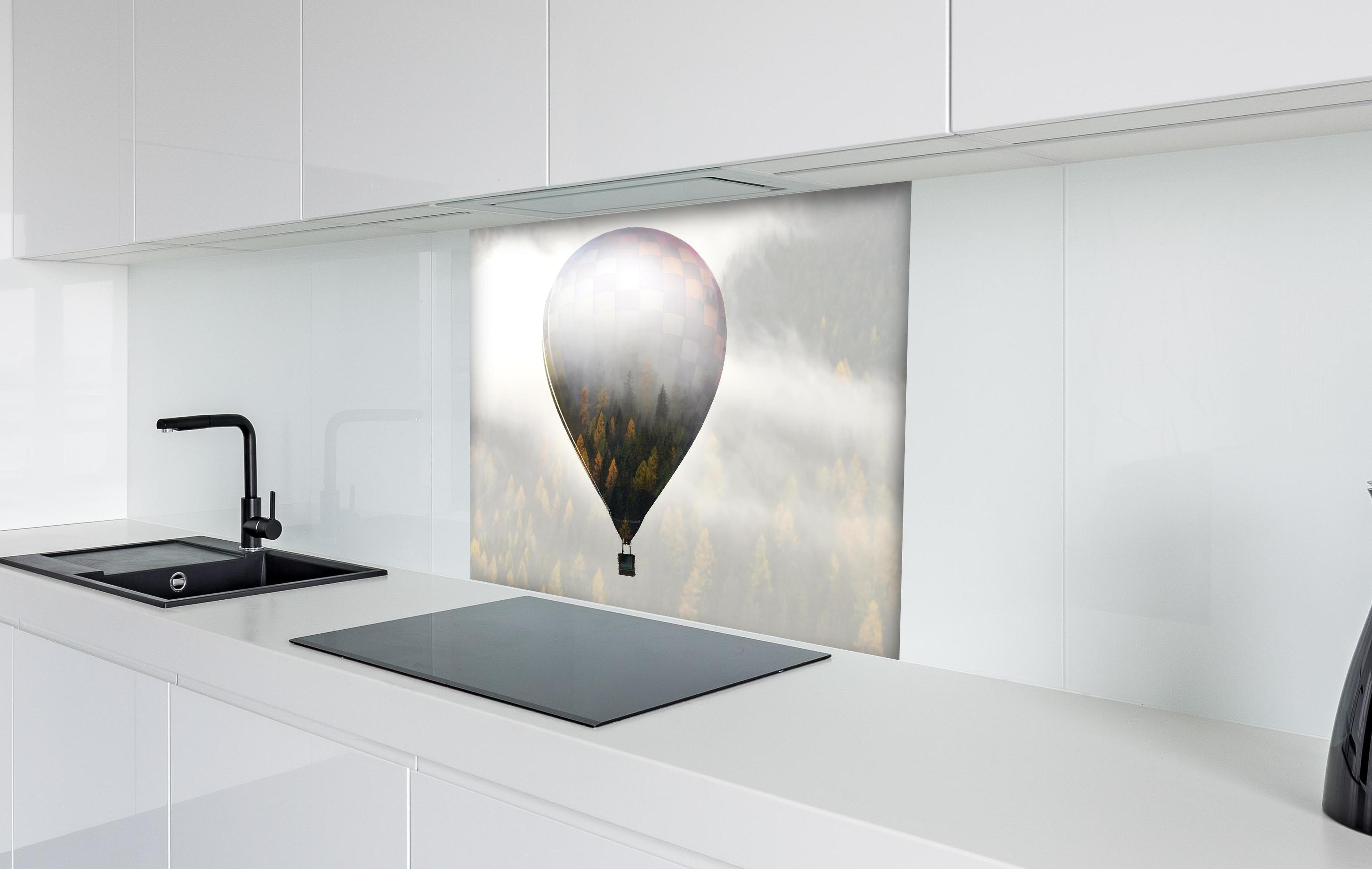 Spritzschutz - Heißluftballon - Spiegelung des Waldes hinter einem Cerankochfeld zwischen Holz-Kochutensilien
