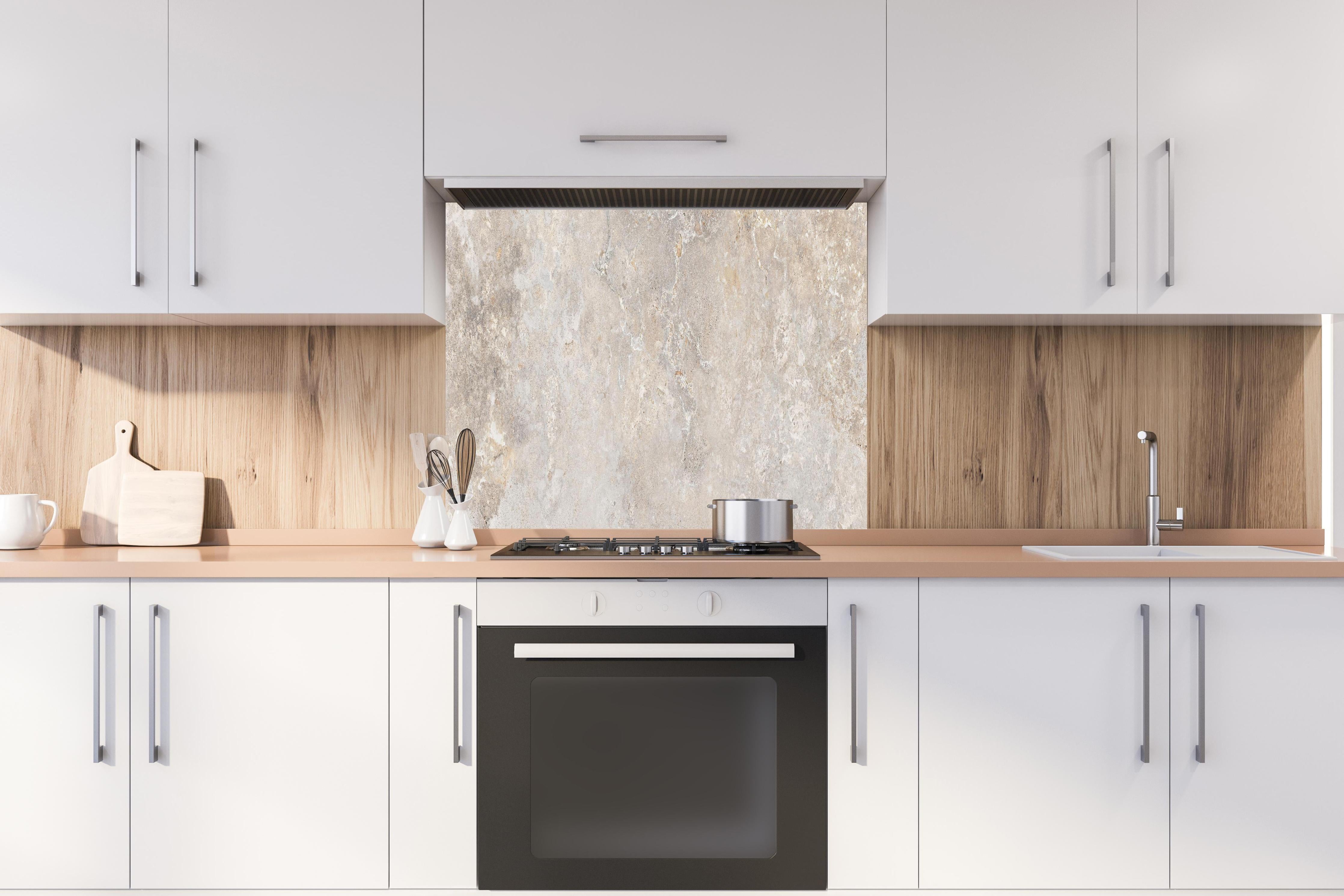 Spritzschutz - Hell bräunliche edle Marmortextur hinter einem Cerankochfeld zwischen Holz-Kochutensilien
