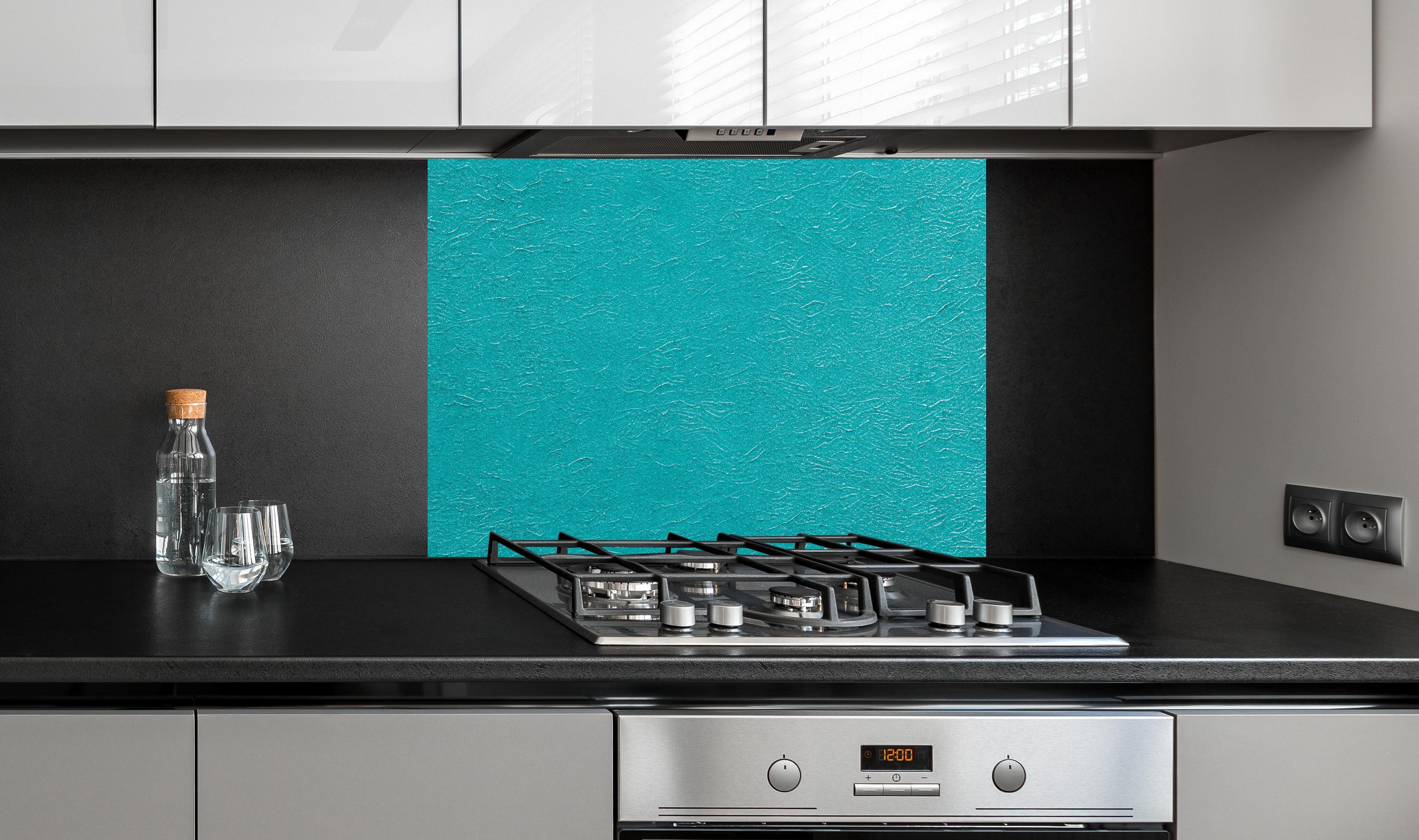 Spritzschutz - Hellblaue bemalte Wand Textur hinter einem Cerankochfeld zwischen Holz-Kochutensilien
