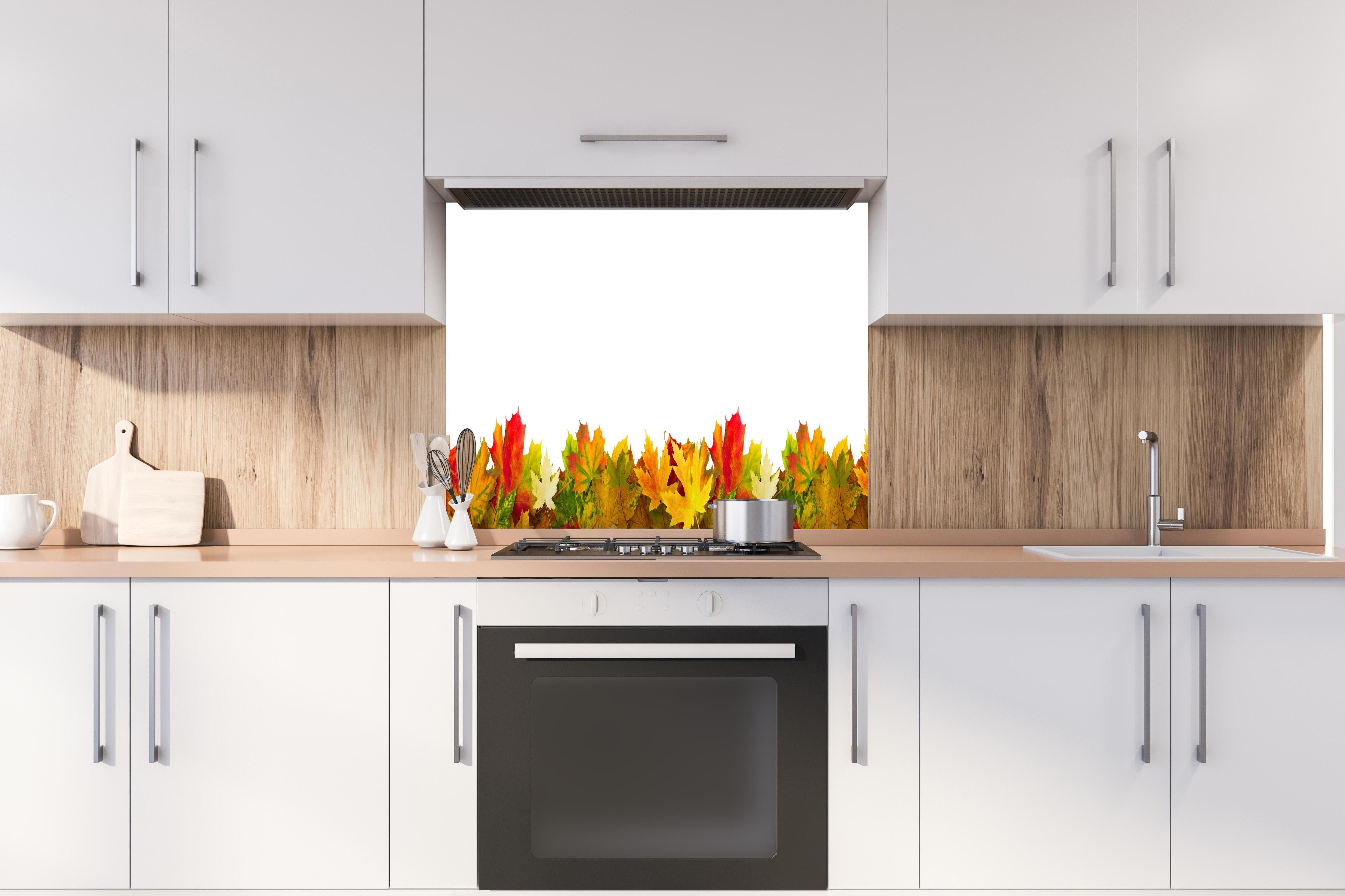 Spritzschutz - Herbst Laub hinter einem Cerankochfeld zwischen Holz-Kochutensilien
