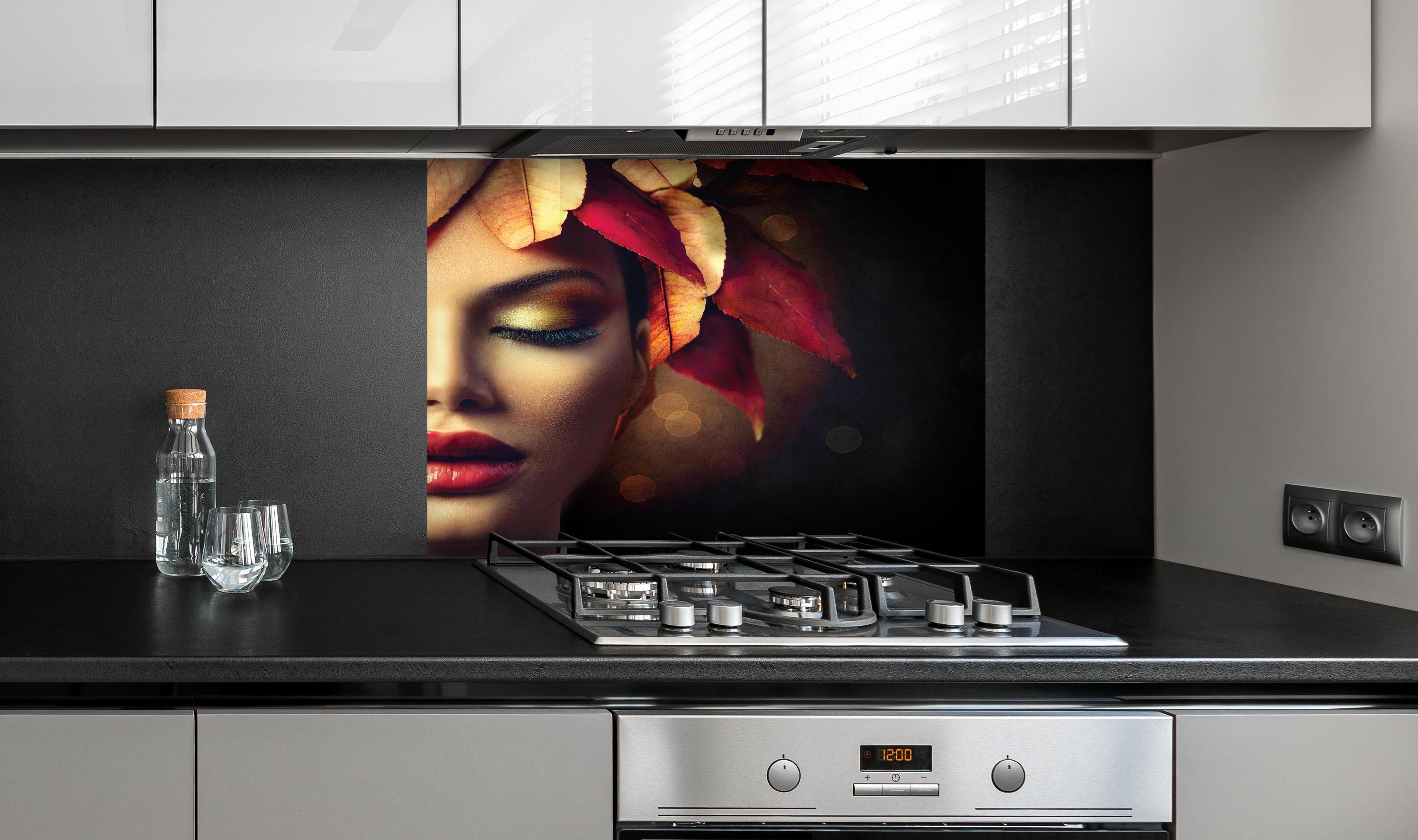 Spritzschutz - Herbstblätter Frisur auf dunklem Hintergrund hinter einem Cerankochfeld zwischen Holz-Kochutensilien
