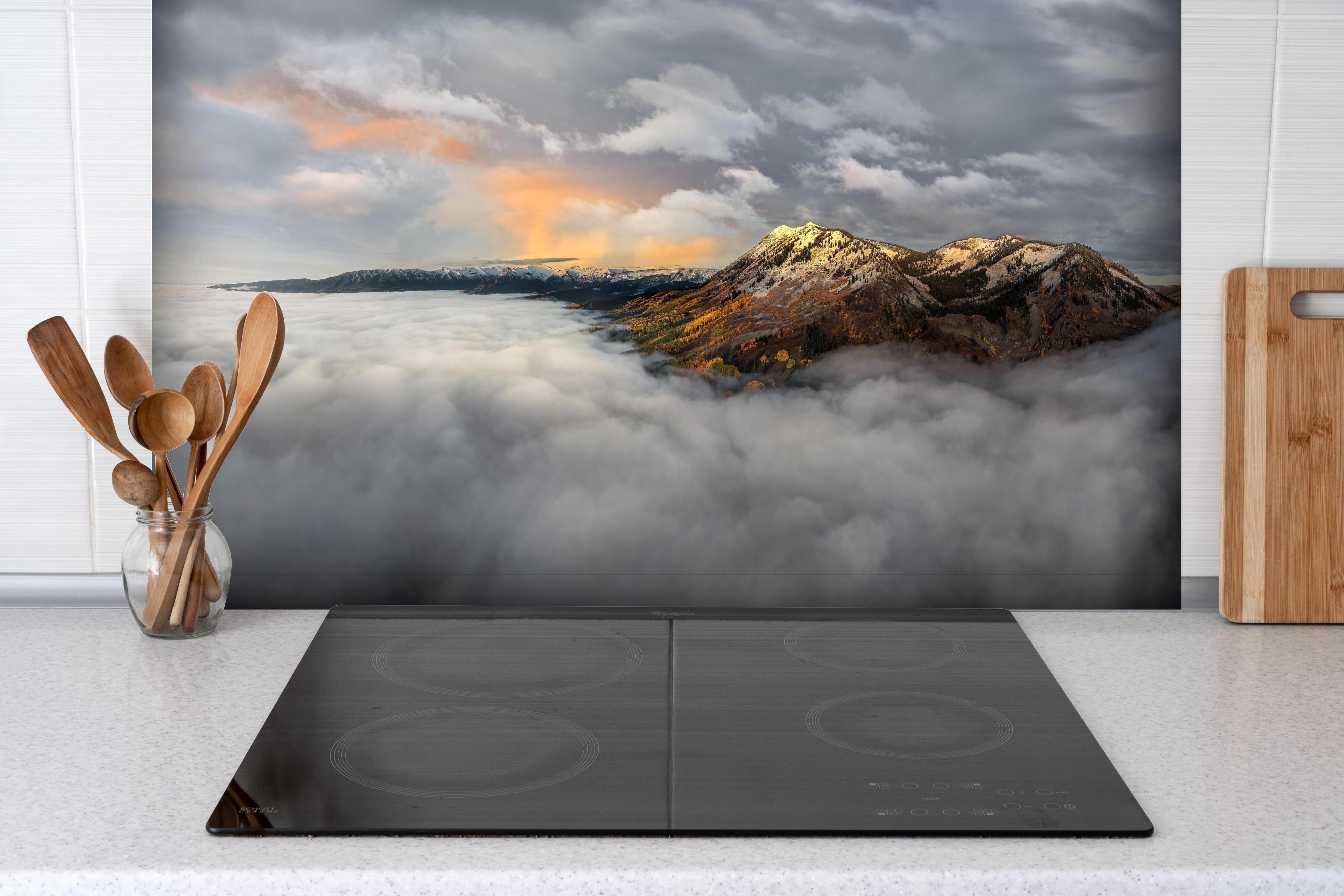 Spritzschutz - Herbstliche Berge im Morgennebel hinter einem Cerankochfeld zwischen Holz-Kochutensilien
