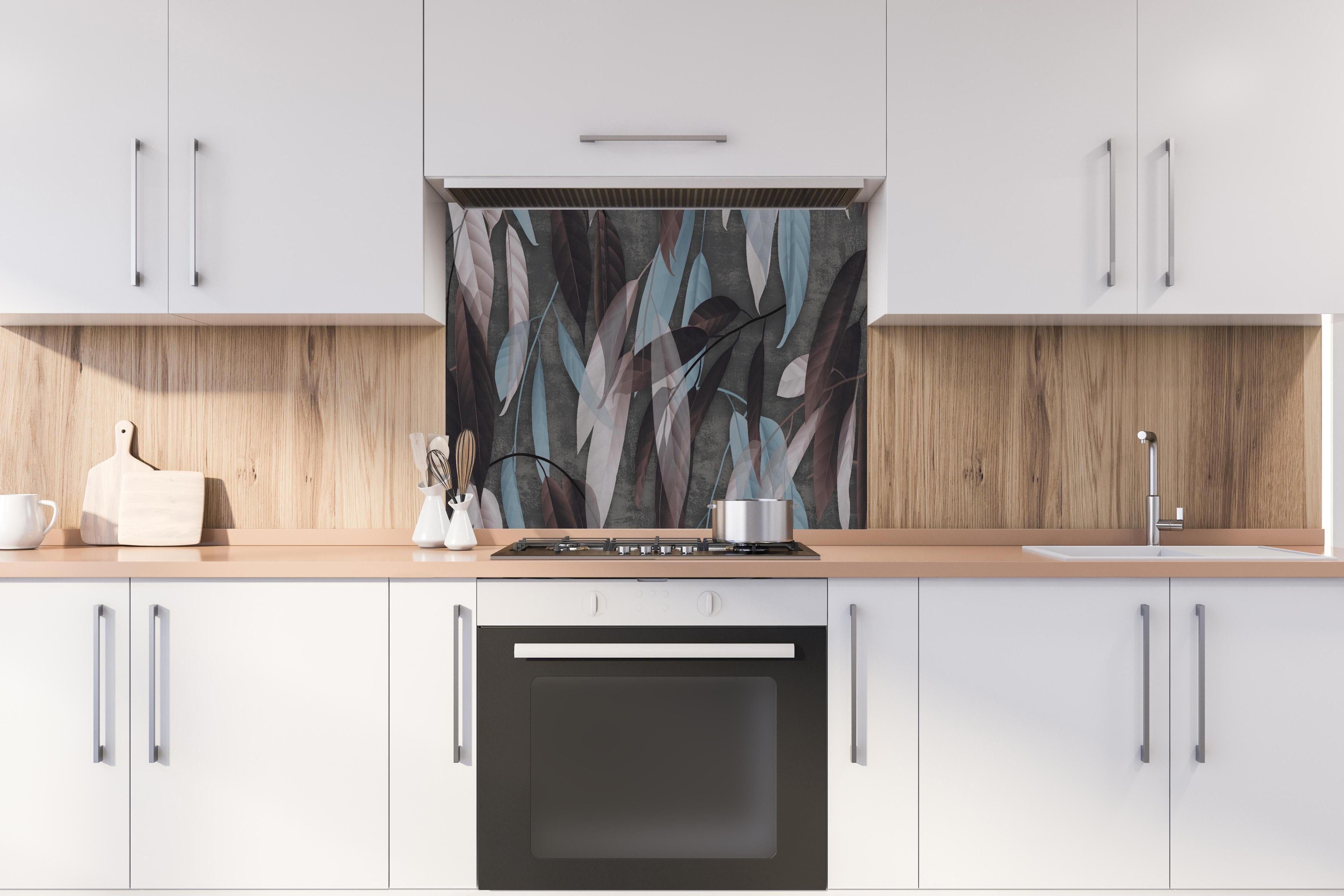 Spritzschutz - Herbstliche Blätter auf Betonoptik Tapete hinter einem Cerankochfeld zwischen Holz-Kochutensilien
