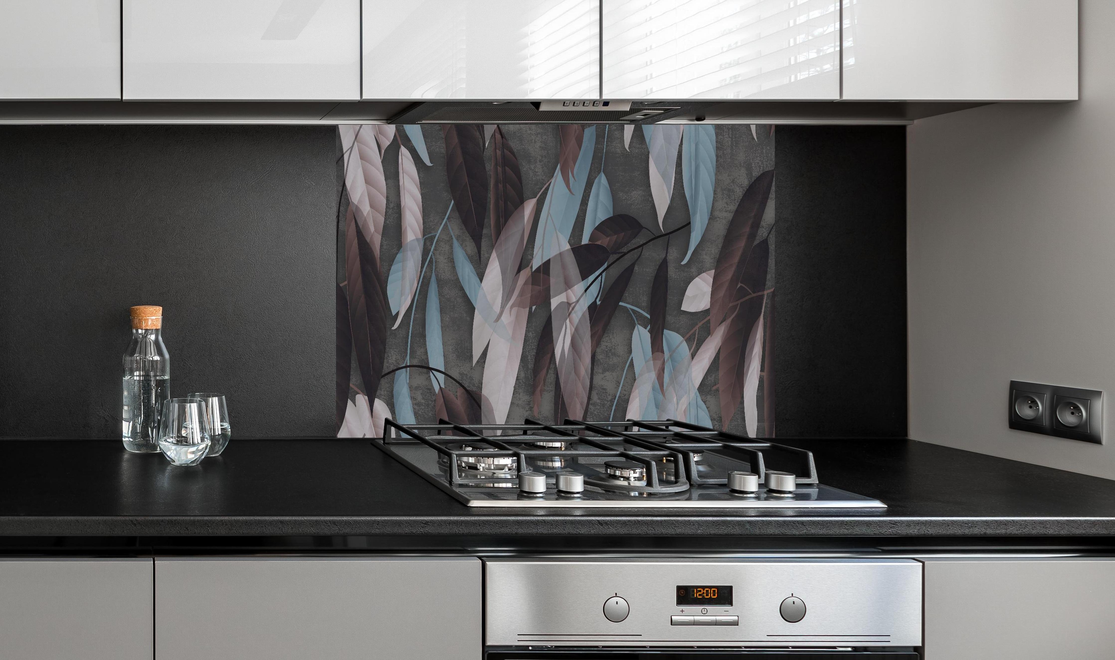 Spritzschutz - Herbstliche Blätter auf Betonoptik Tapete hinter einem Cerankochfeld zwischen Holz-Kochutensilien
