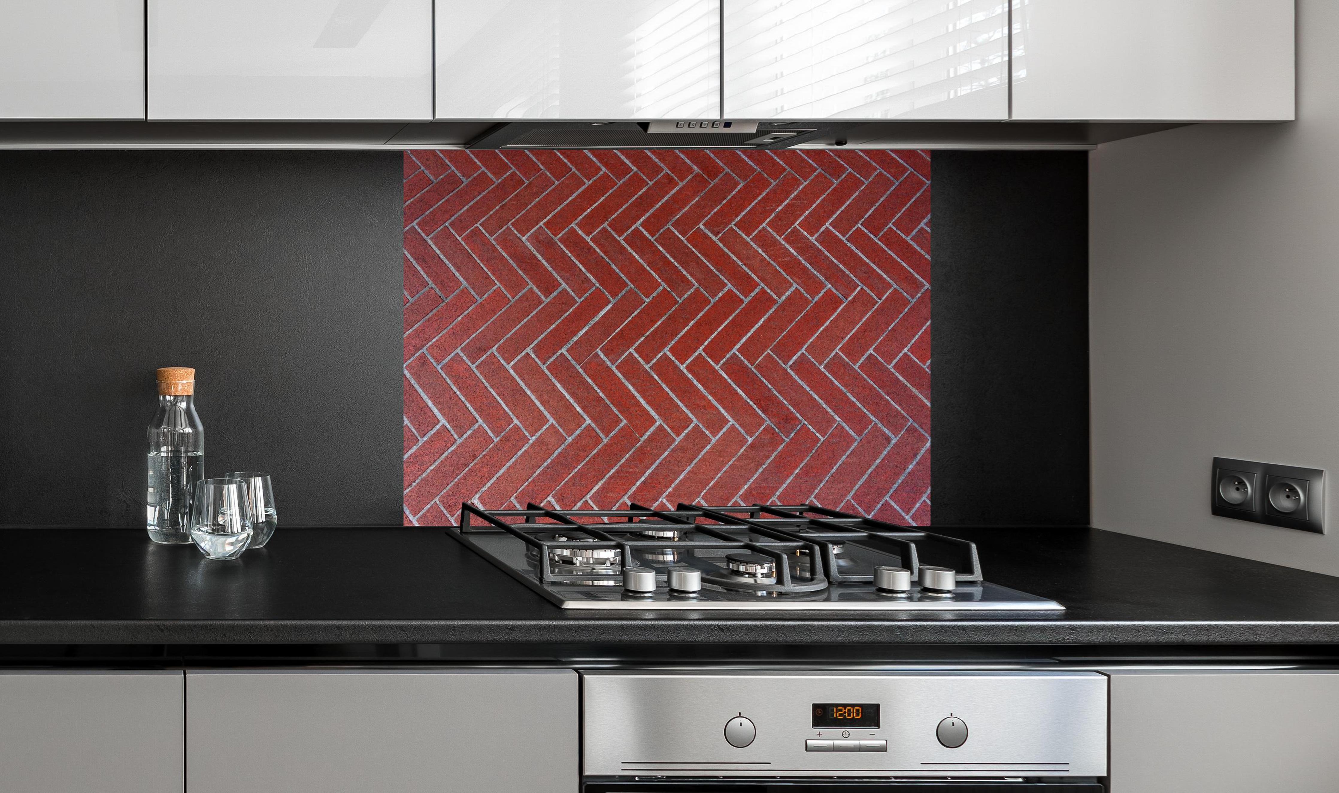 Spritzschutz - Herringbone Pattern Red Outdoor Bricks hinter einem Cerankochfeld zwischen Holz-Kochutensilien
