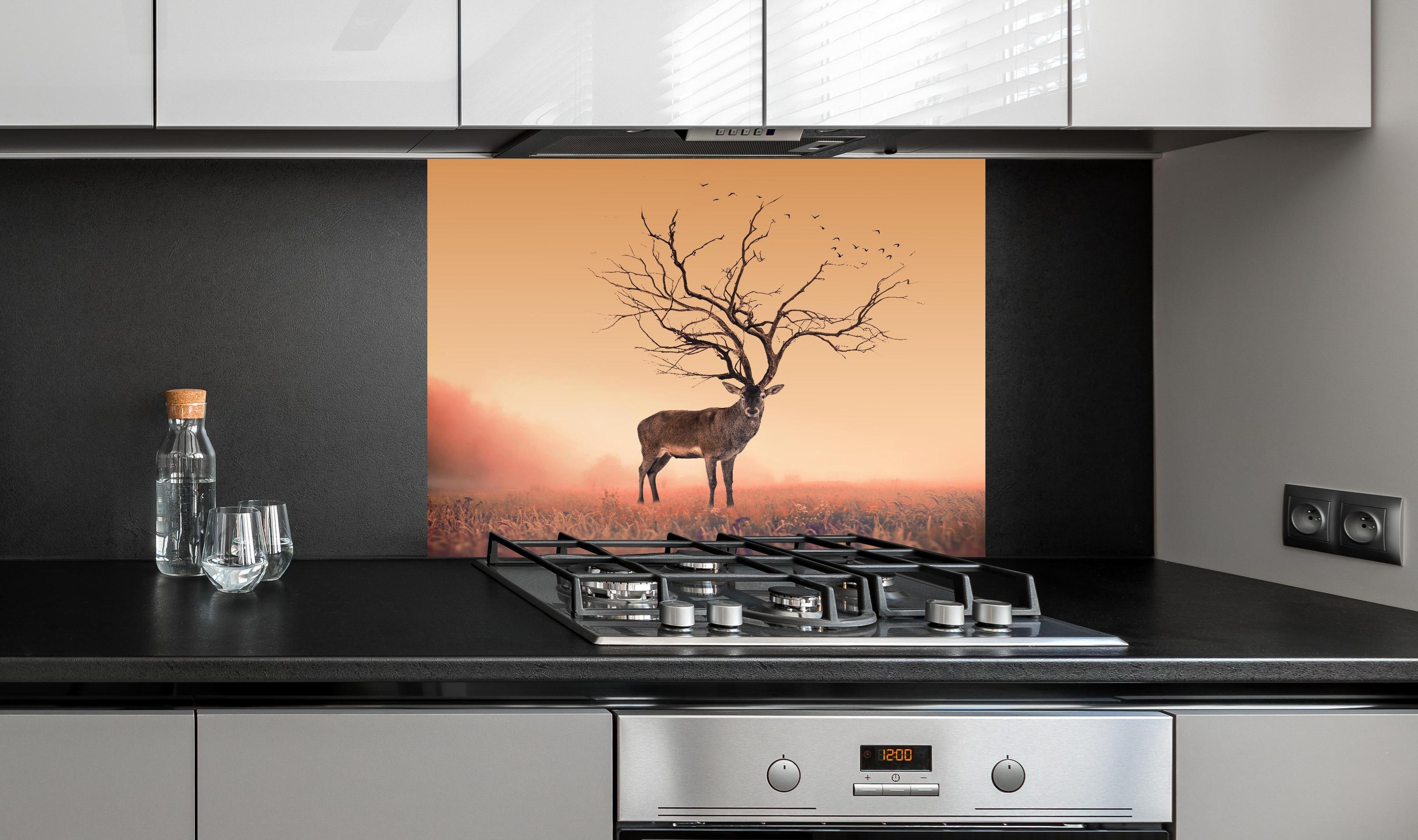 Spritzschutz - Hirsch mit abstraktem Baum-Geweih hinter einem Cerankochfeld zwischen Holz-Kochutensilien
