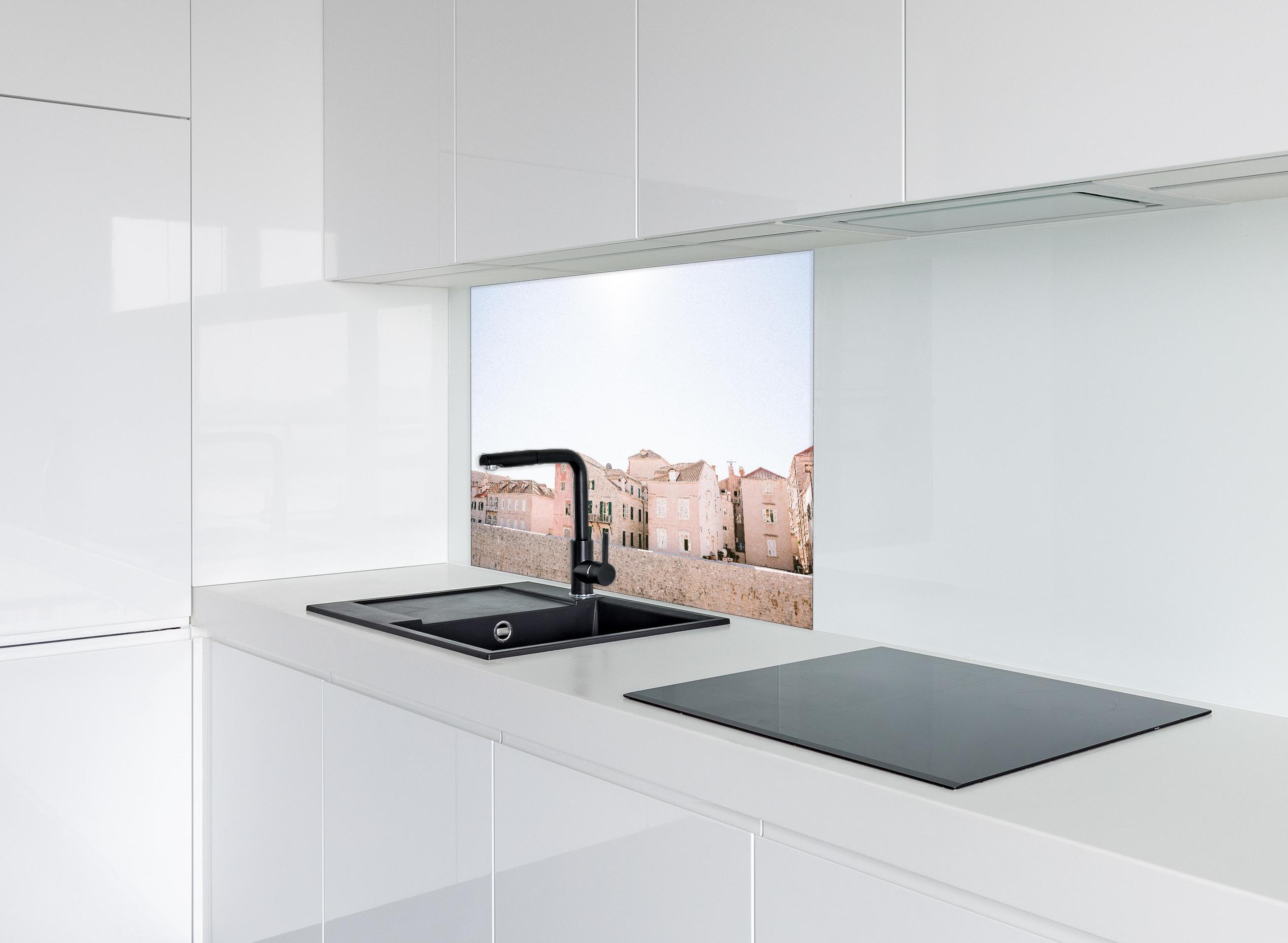 Spritzschutz - Historische Bauten Dubrovnik in Pastell hinter einem Cerankochfeld zwischen Holz-Kochutensilien
