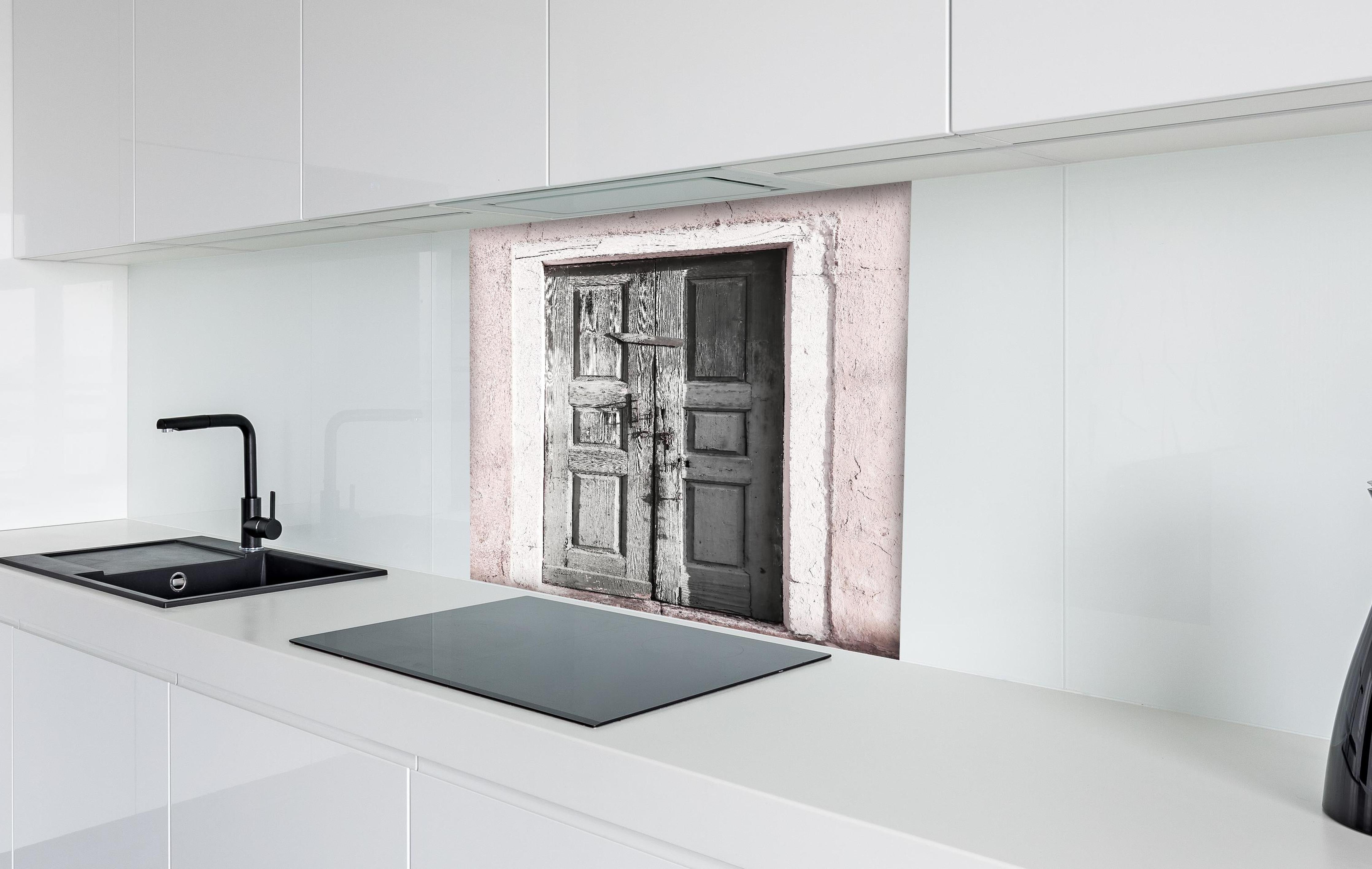 Spritzschutz - Historische Tür hinter einem Cerankochfeld zwischen Holz-Kochutensilien
