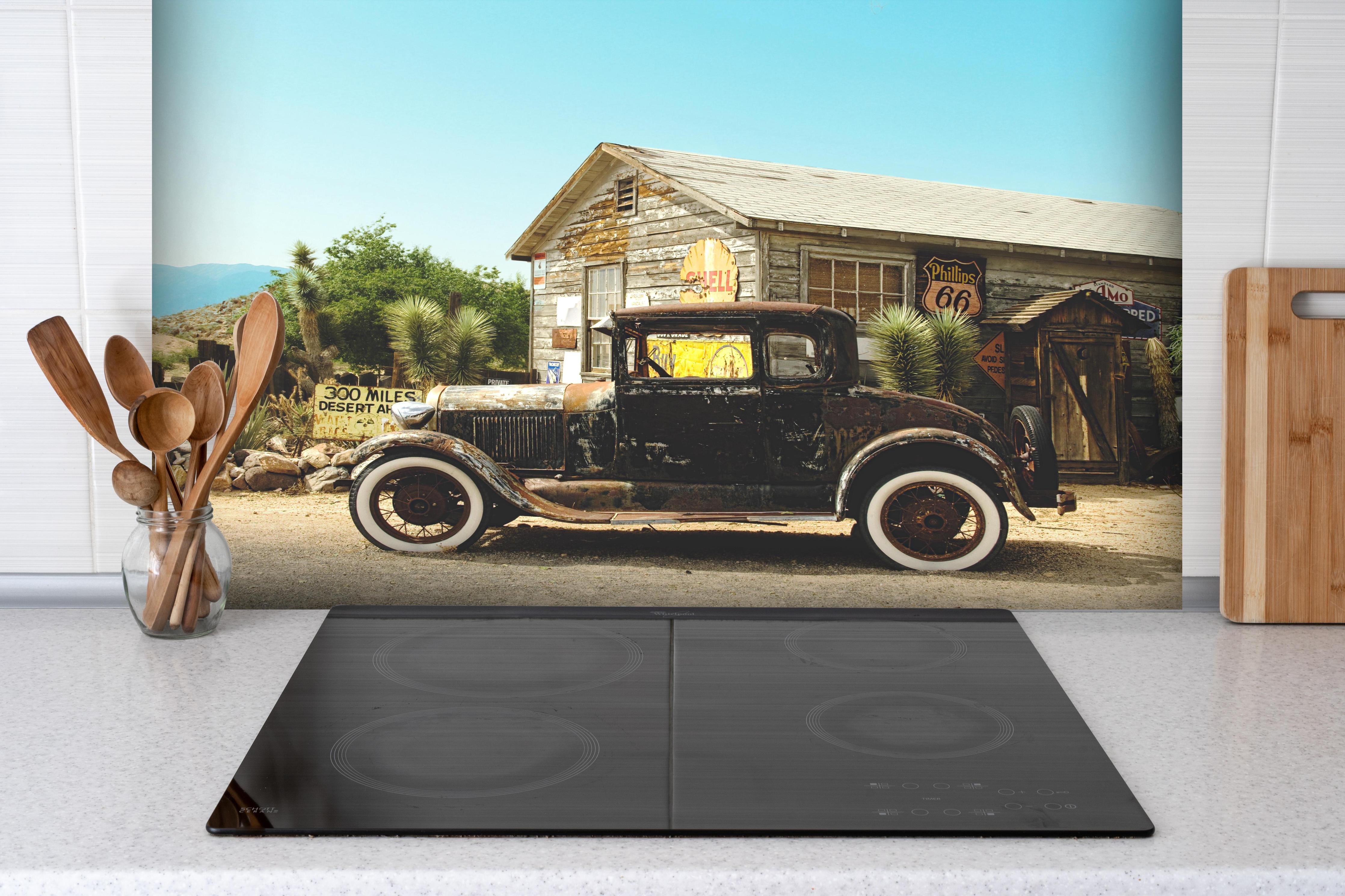 Spritzschutz - Historischer Oldtimer vor Arizona-Gebäude hinter einem Cerankochfeld zwischen Holz-Kochutensilien
