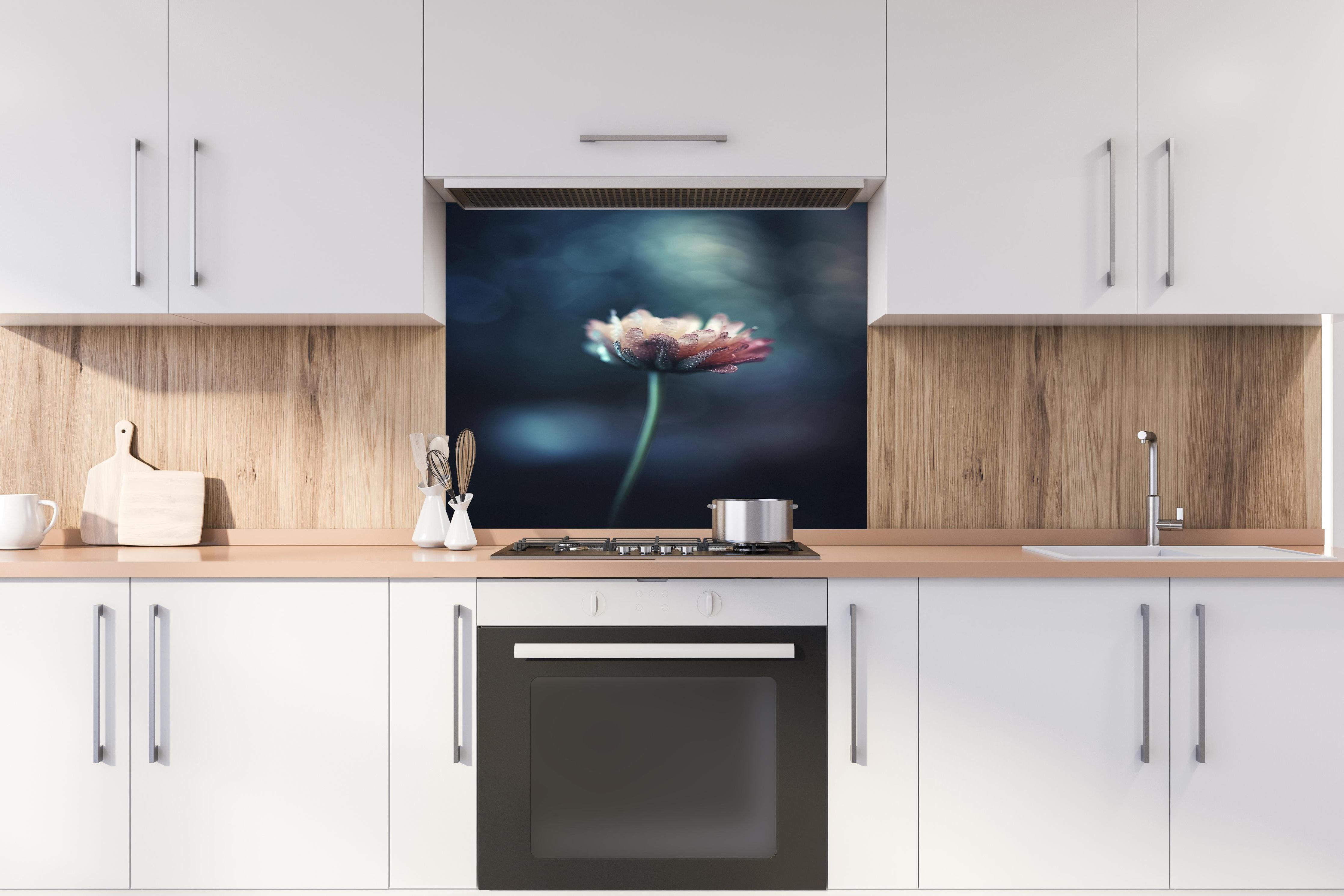 Spritzschutz - Hochauflösende Blume - verschwommen hinter einem Cerankochfeld zwischen Holz-Kochutensilien
