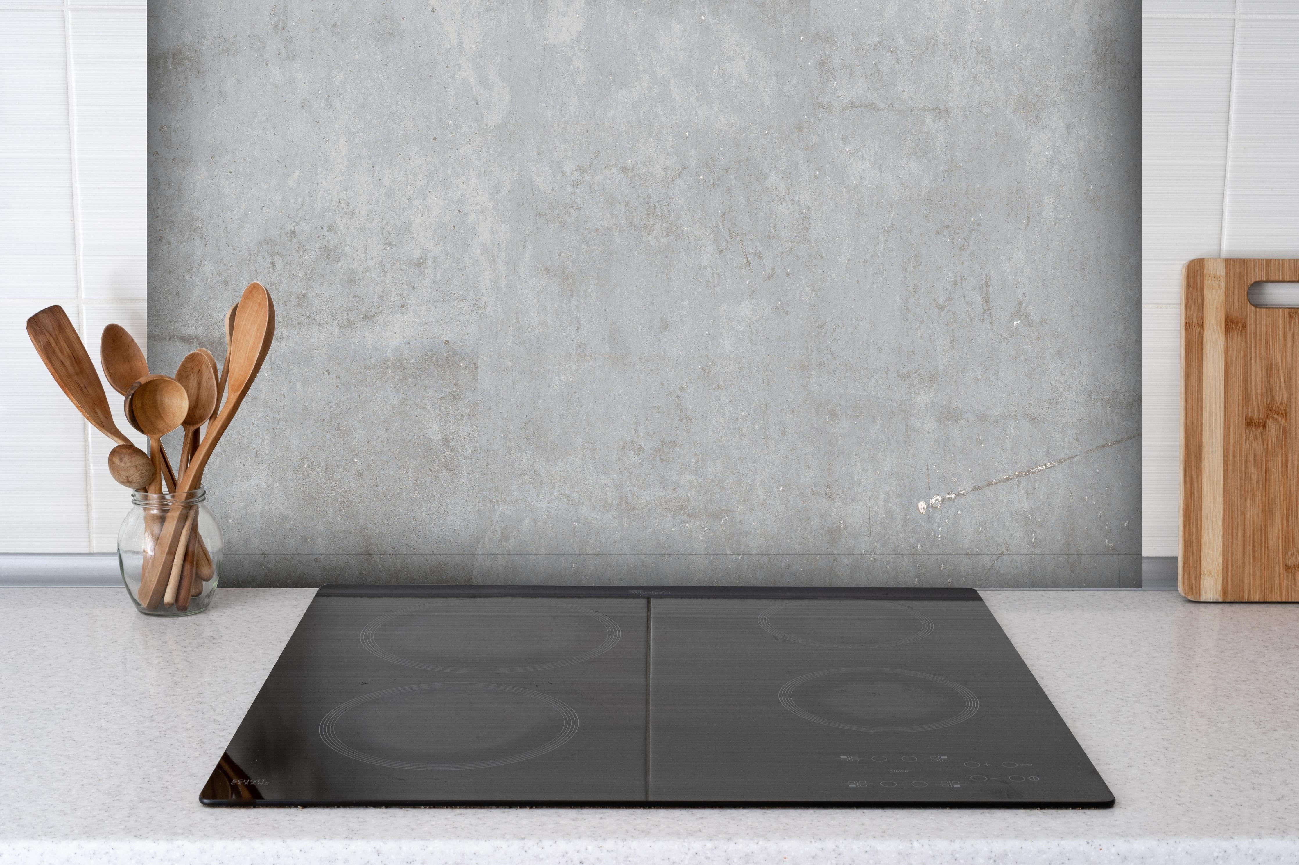 Spritzschutz - Hochauflösende grau-weiße Marmorstruktur hinter einem Cerankochfeld zwischen Holz-Kochutensilien
