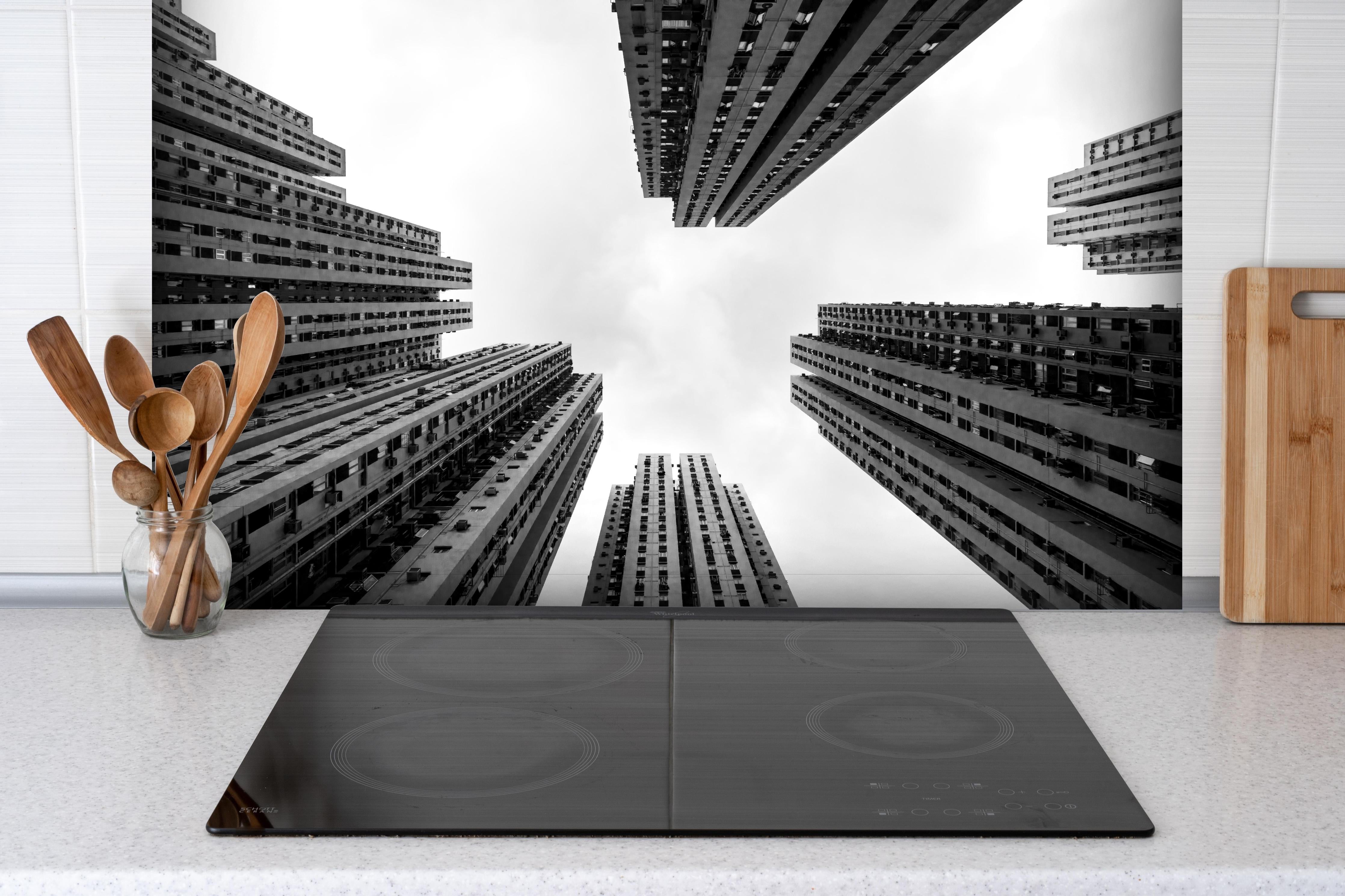 Spritzschutz - Hochhäuser - Schwarz-weiß hinter einem Cerankochfeld zwischen Holz-Kochutensilien
