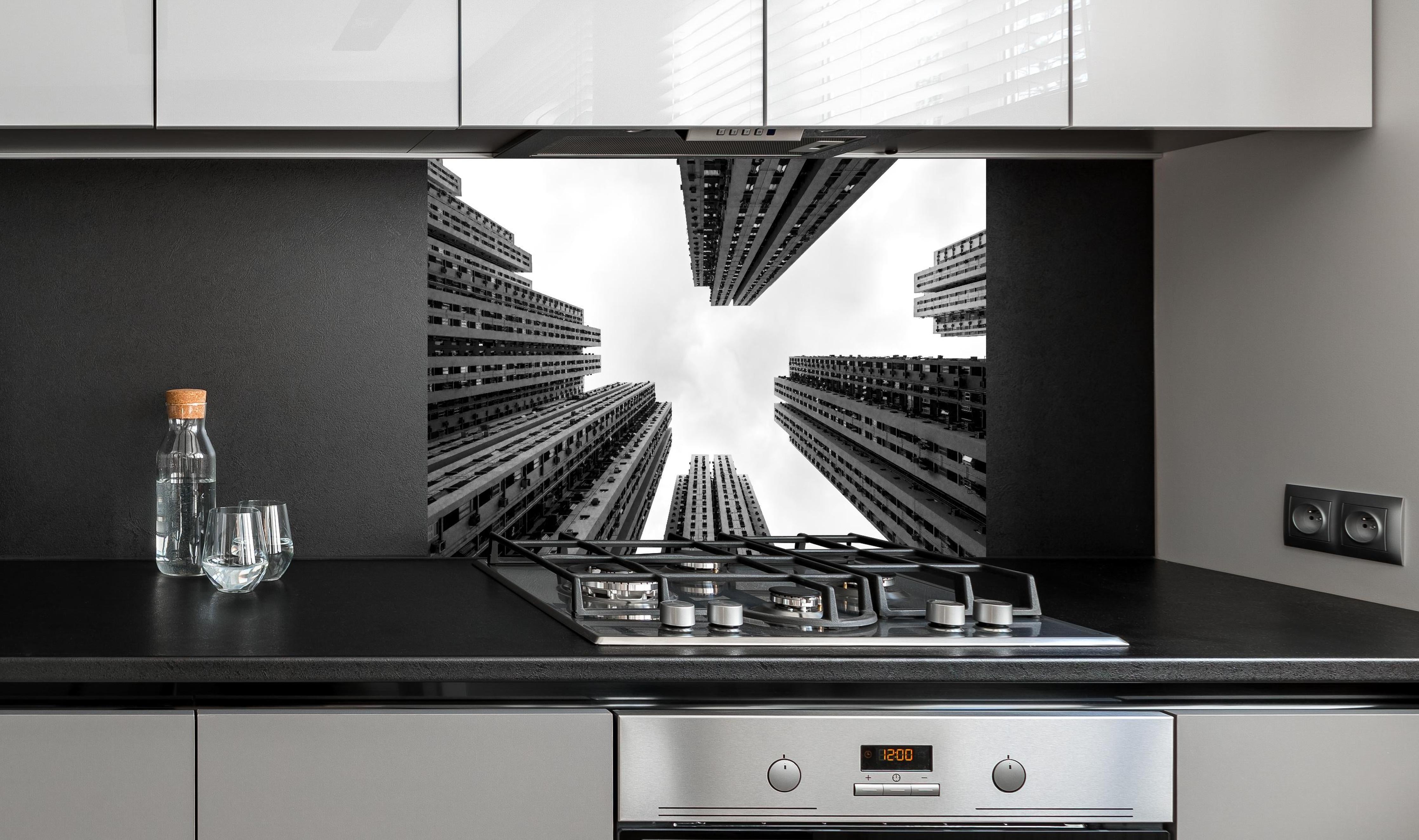 Spritzschutz - Hochhäuser - Schwarz-weiß hinter einem Cerankochfeld zwischen Holz-Kochutensilien
