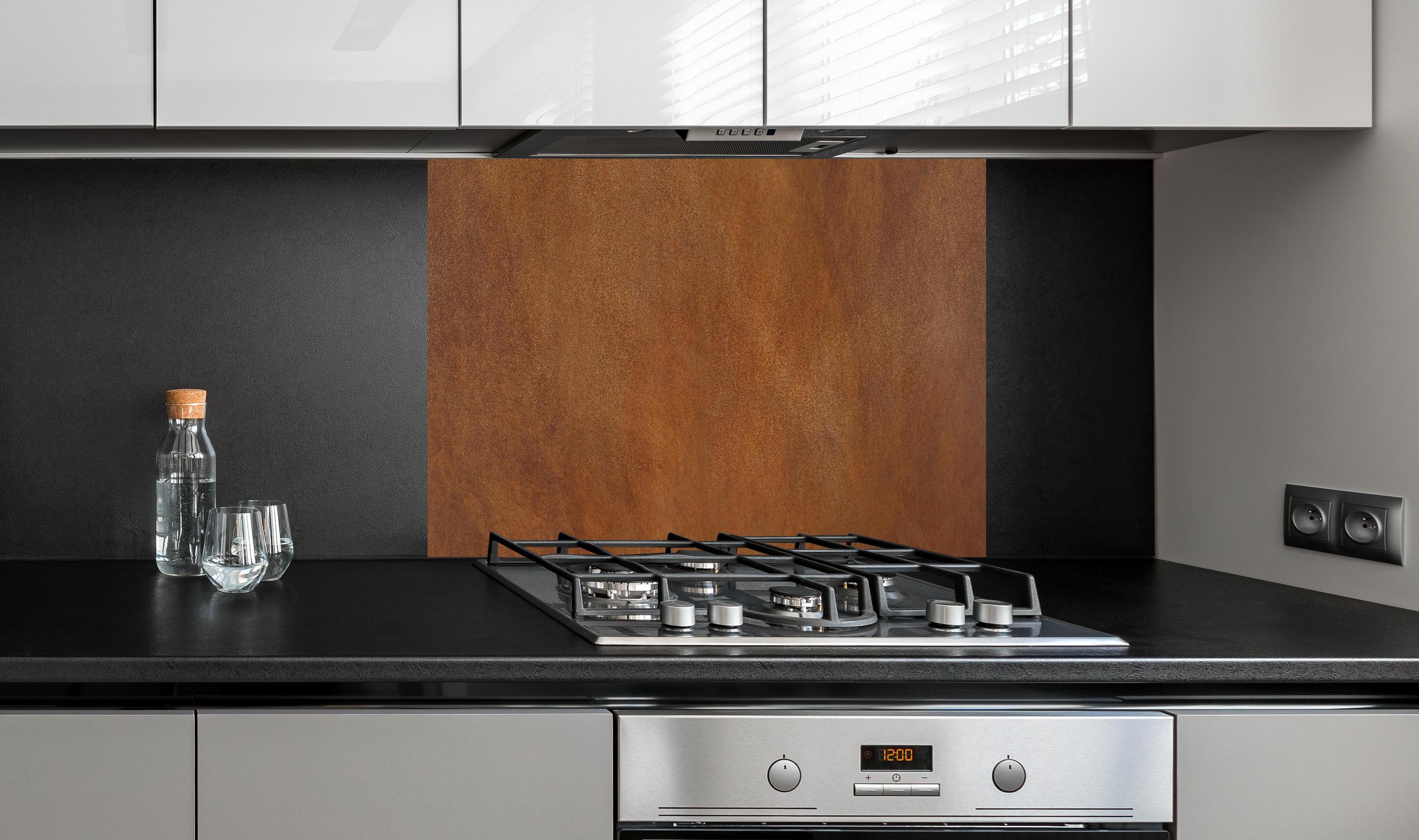 Spritzschutz - Hochwertige abstrakte braune Lederoberfläche hinter einem Cerankochfeld zwischen Holz-Kochutensilien
