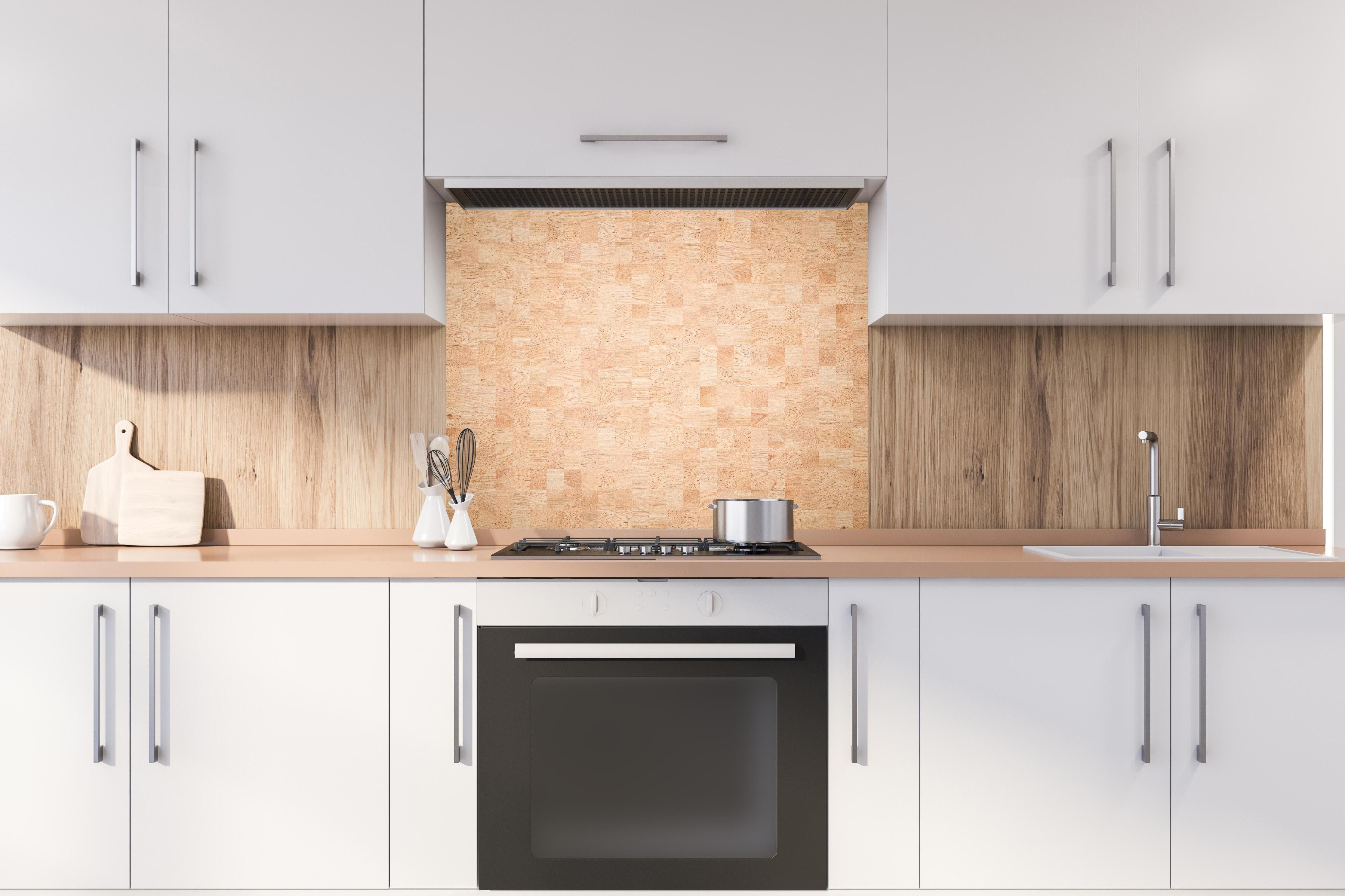 Spritzschutz - Holztextur aus Eschenholz hinter einem Cerankochfeld zwischen Holz-Kochutensilien
