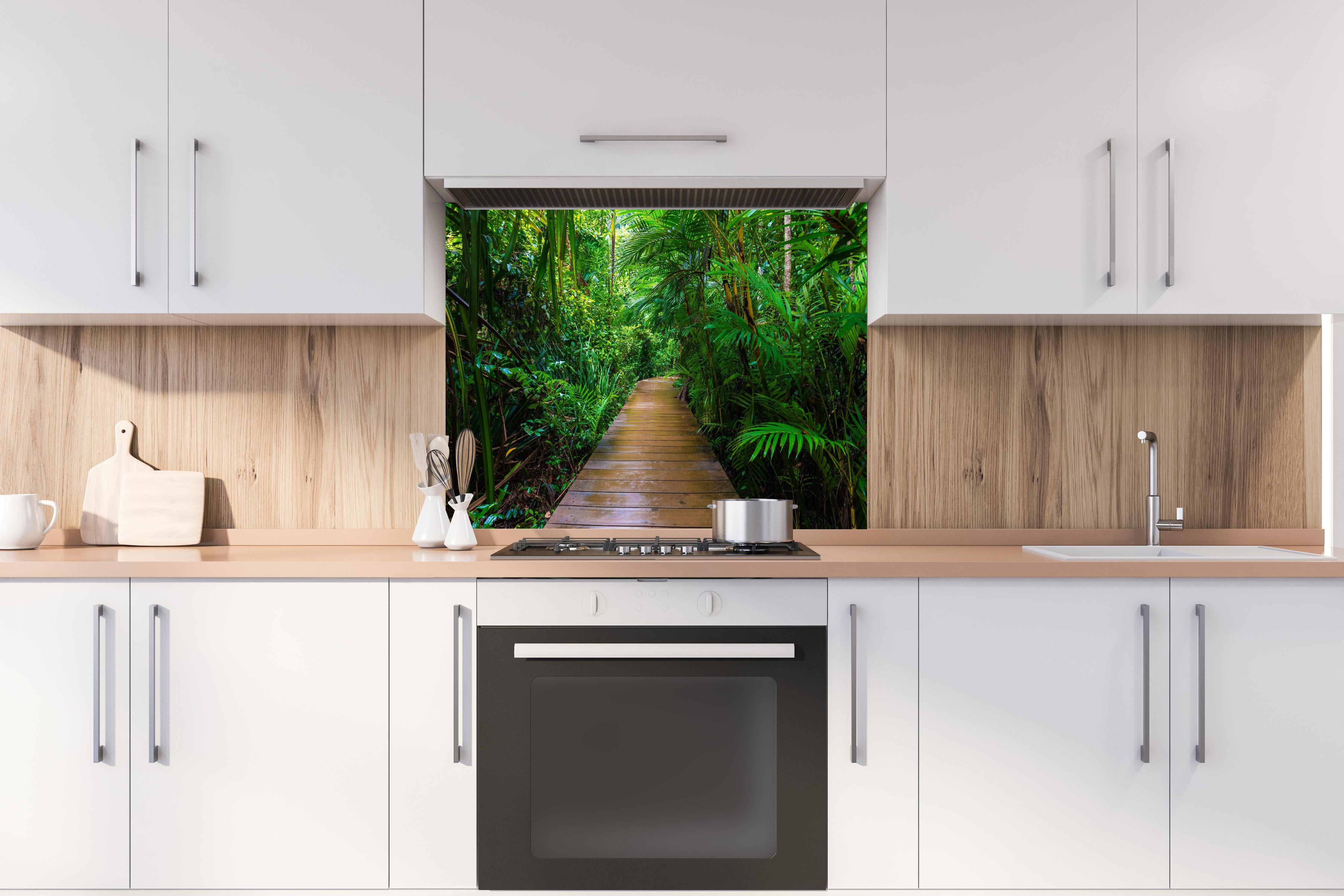 Spritzschutz - Holzweg durch dichten grünen Mangrovenwald hinter einem Cerankochfeld zwischen Holz-Kochutensilien
