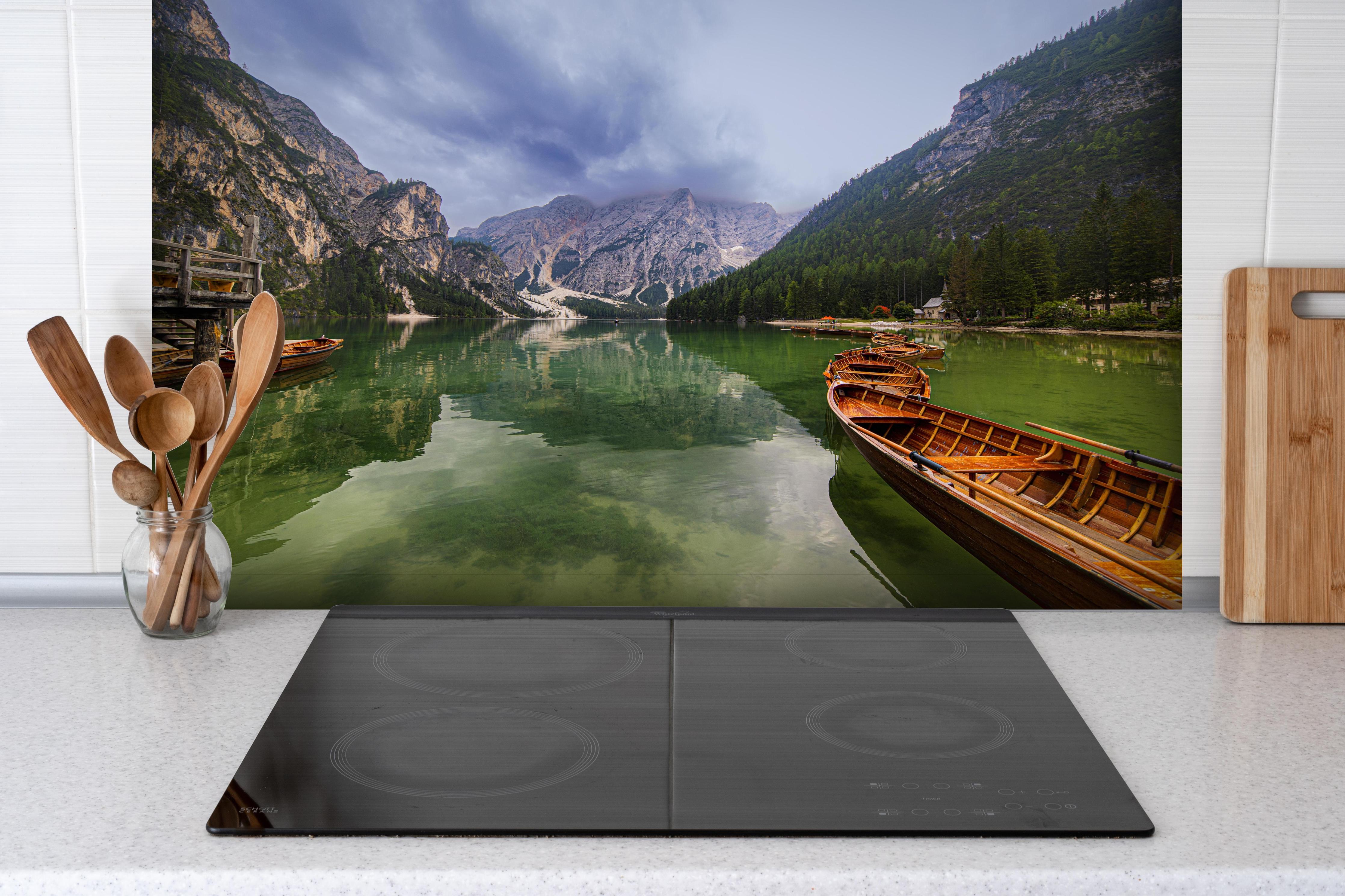 Spritzschutz - Idyllische Bergsee-Landschaft Dolomiten hinter einem Cerankochfeld zwischen Holz-Kochutensilien
