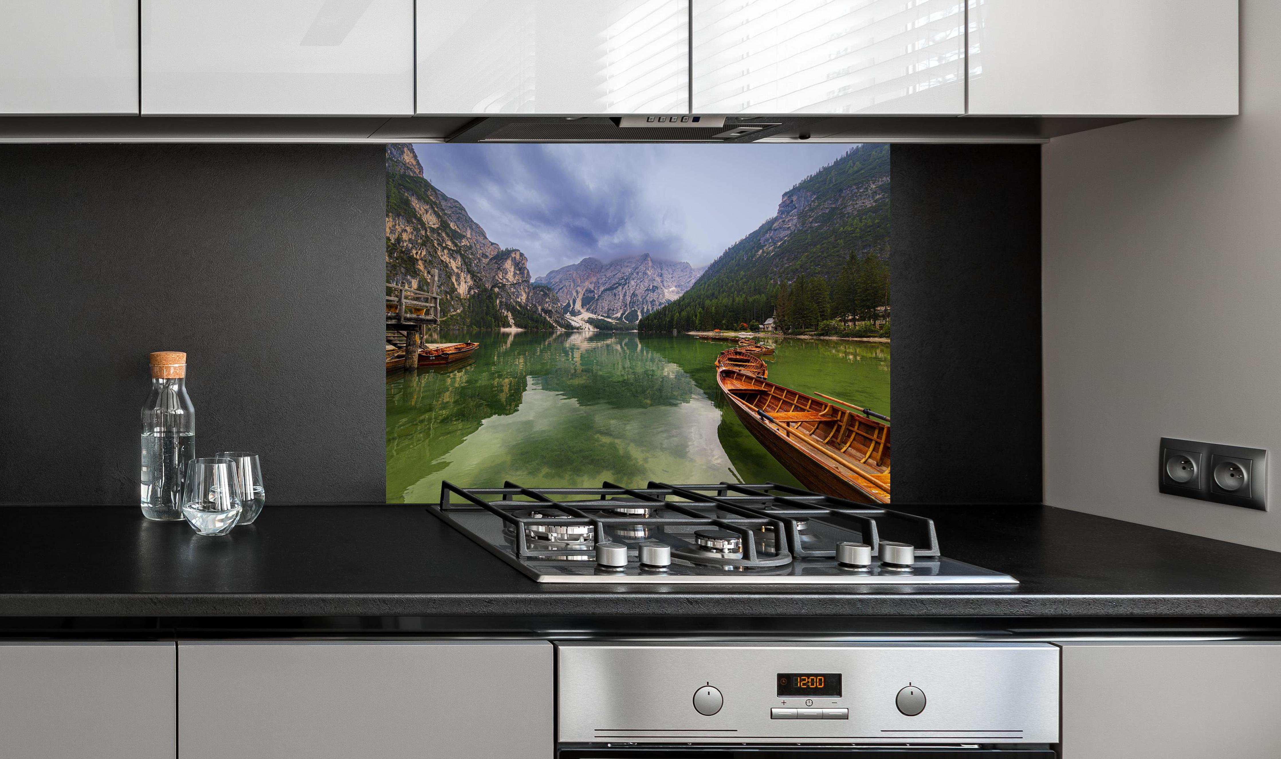 Spritzschutz - Idyllische Bergsee-Landschaft Dolomiten hinter einem Cerankochfeld zwischen Holz-Kochutensilien

