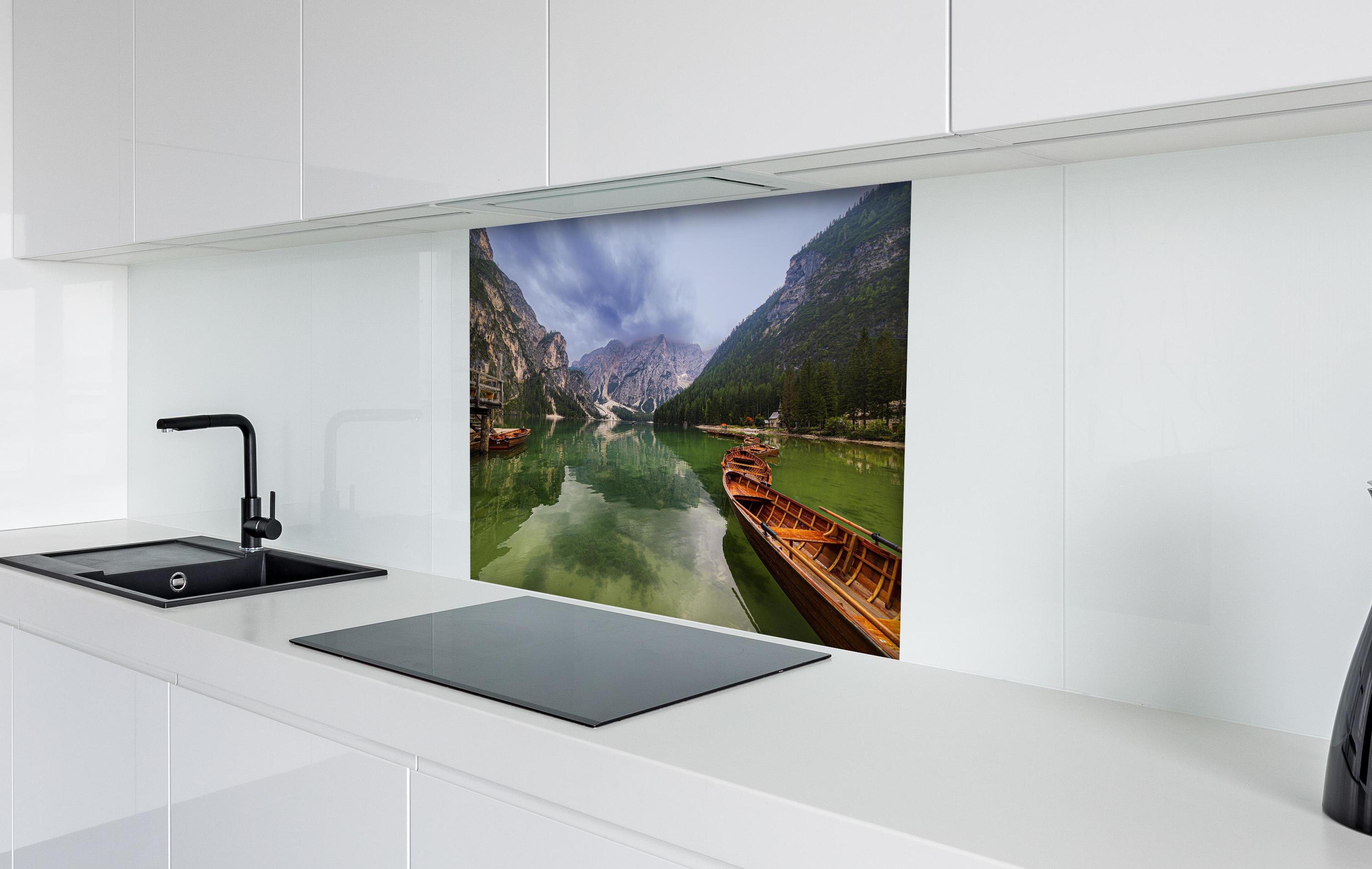 Spritzschutz - Idyllische Bergsee-Landschaft Dolomiten hinter einem Cerankochfeld zwischen Holz-Kochutensilien
